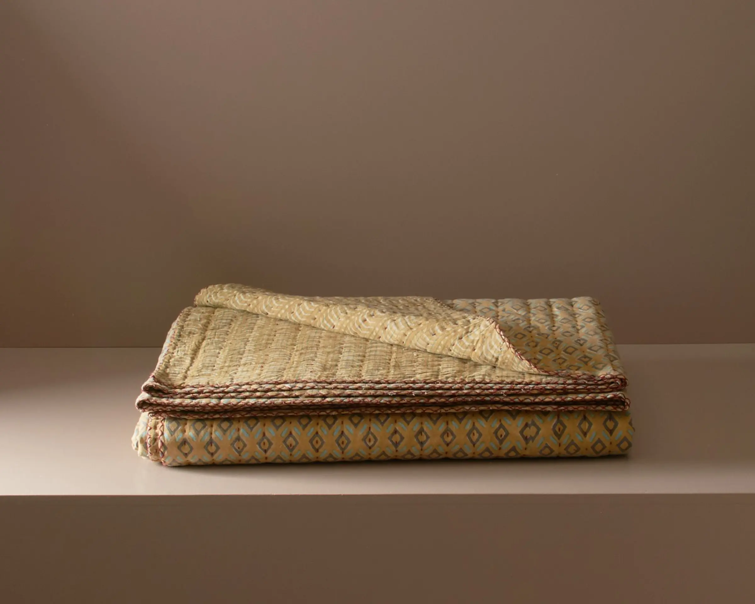 a block printed kantha quilt with diamond design