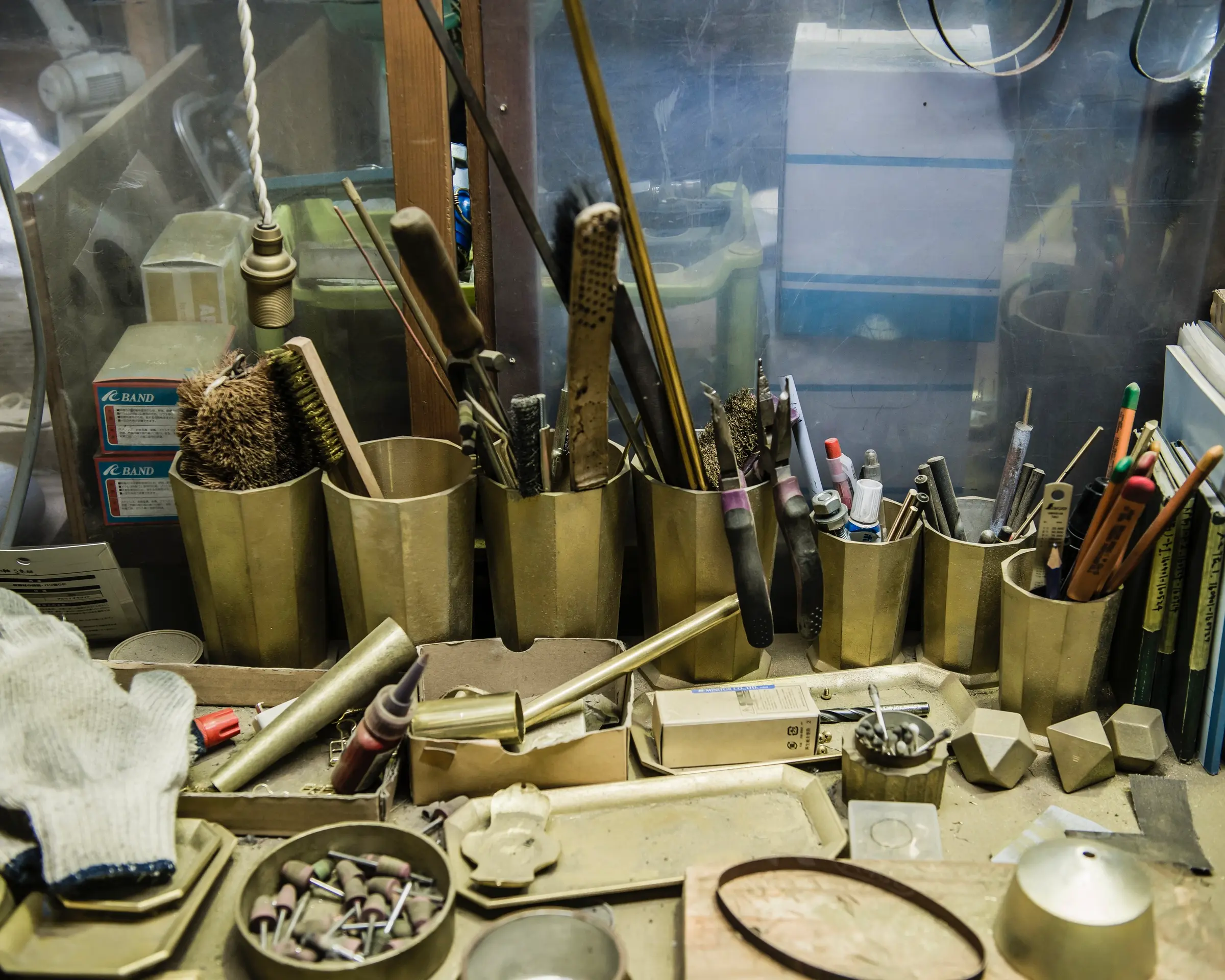 in situ work bench photo in a brass factory in Japan with assorted brass vessels and tools