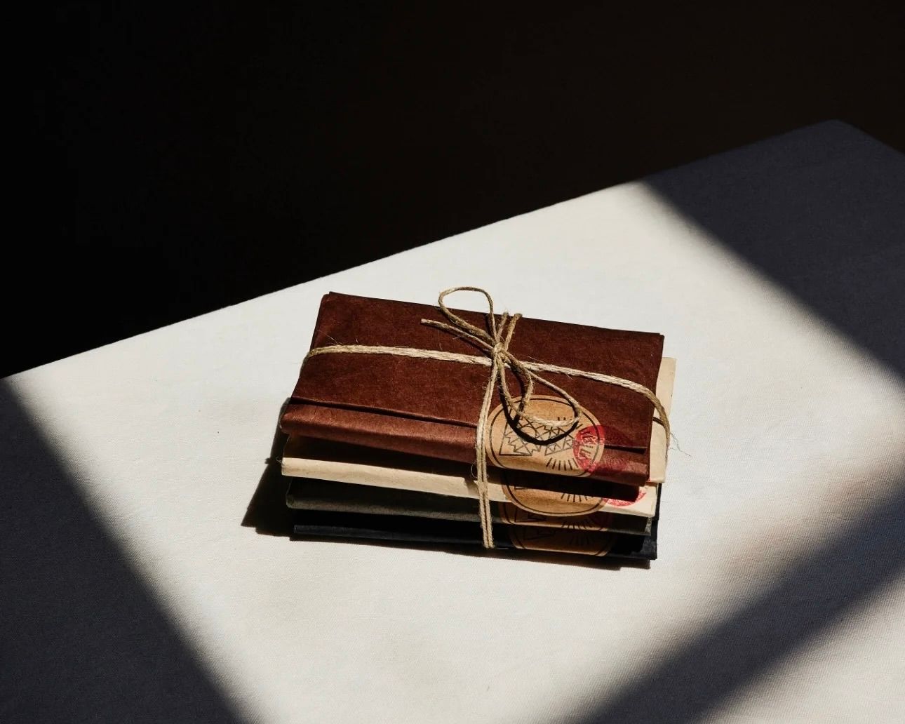 incausa incense parcels stacked with a ribbon on a plain background