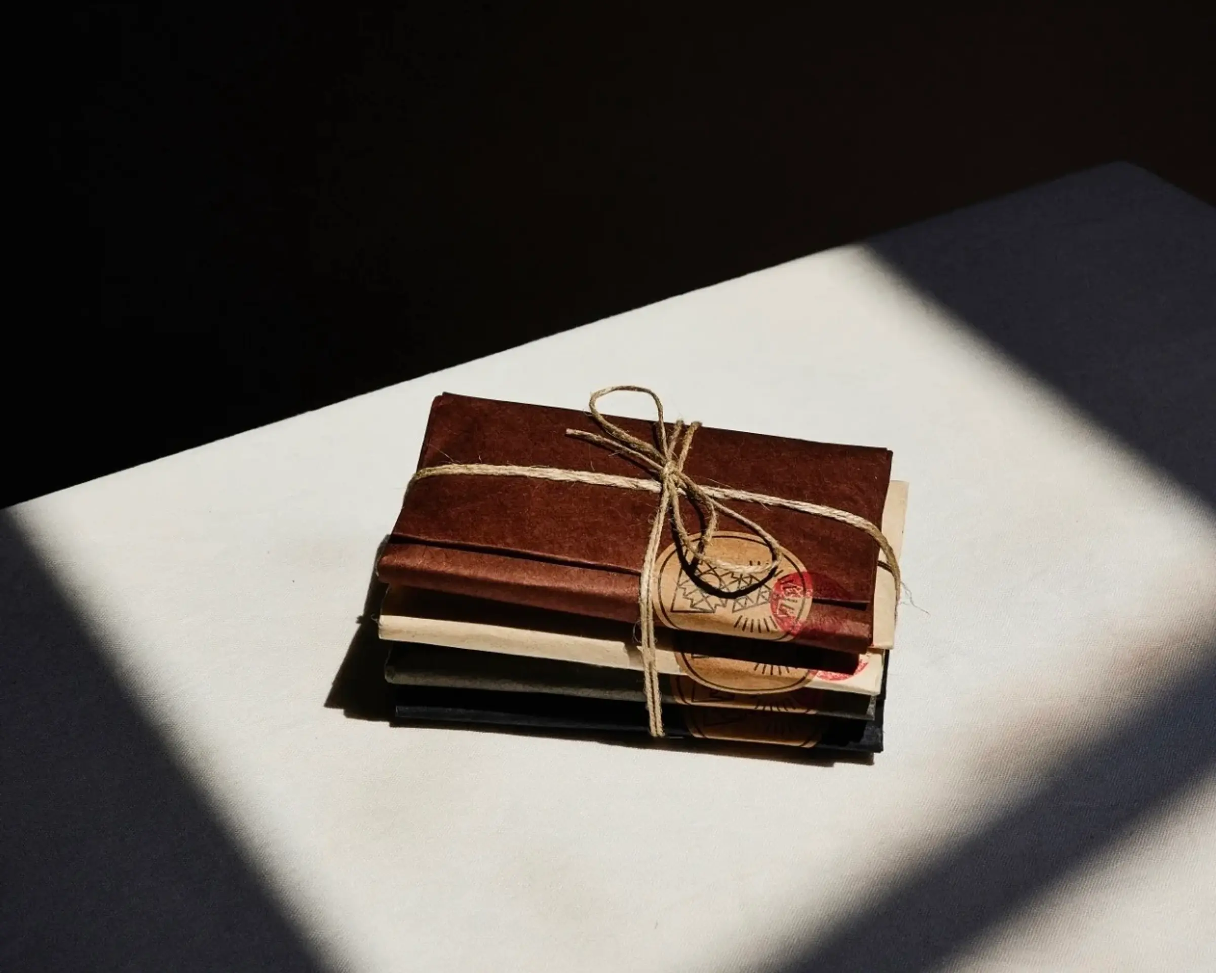 incausa incense parcels stacked with a ribbon on a plain background