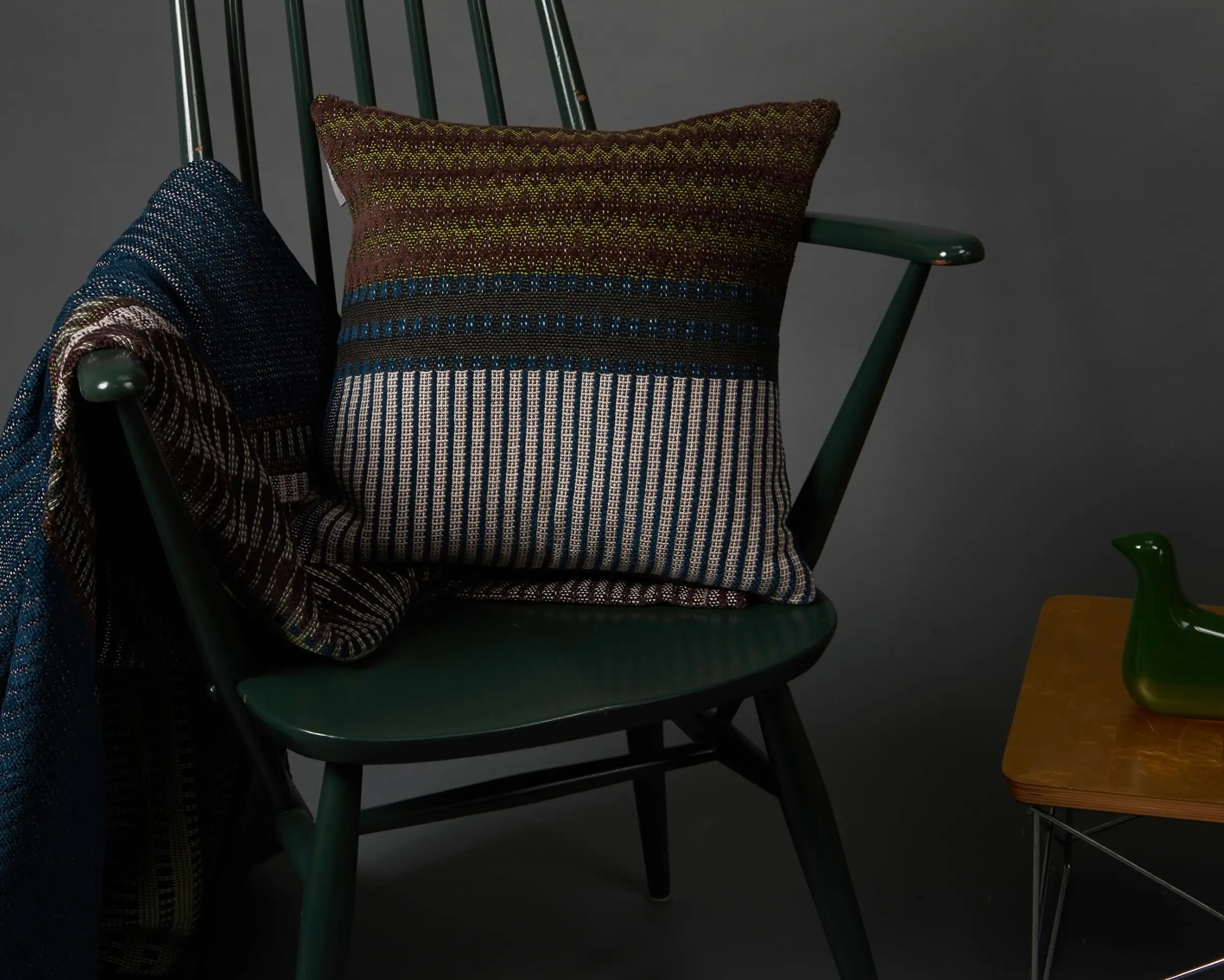blanket and cushion draped on a wooden chair