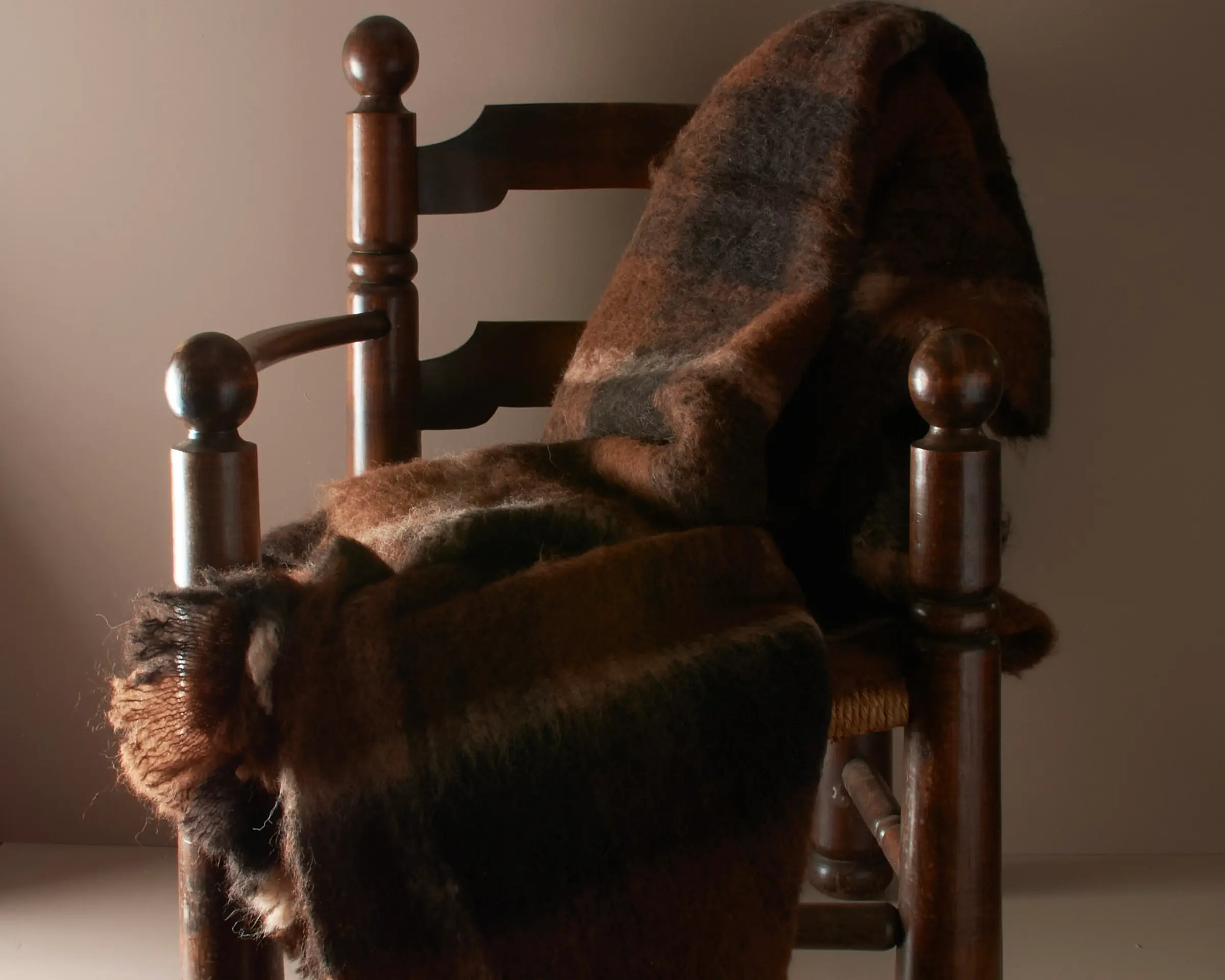 folded alpaca blanket on a French wooden chair