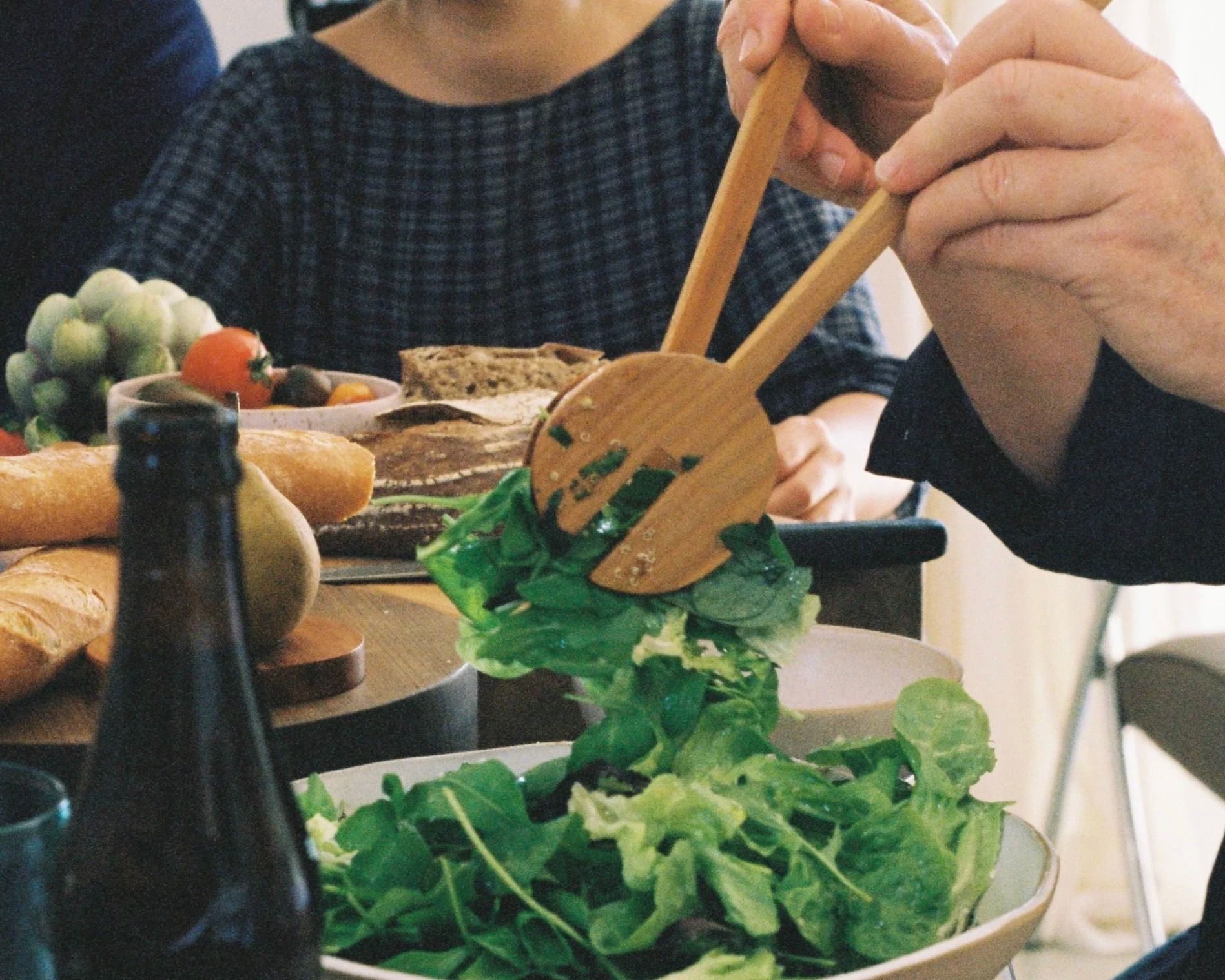 Courtney petleys hand carved salad serving spoons made from Swamp kauri in Auckland New Zealand, in situ serving a salad at the table