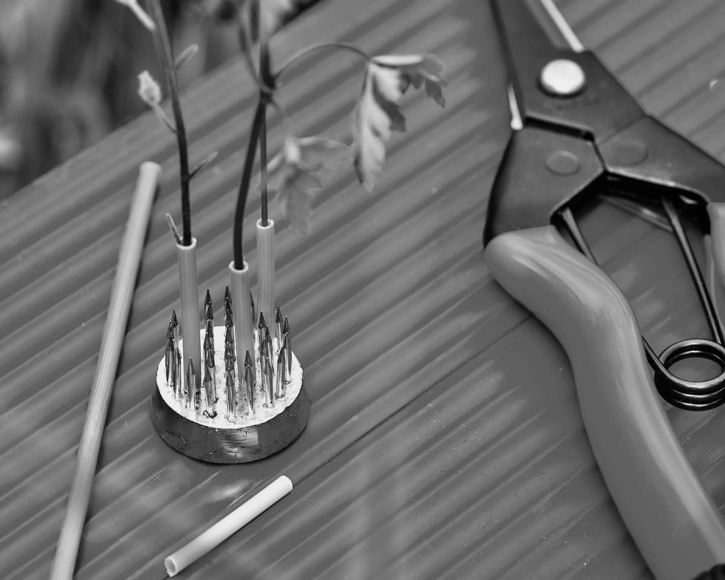 A close up of the mini Kenzan Ikebana set holding small flowers