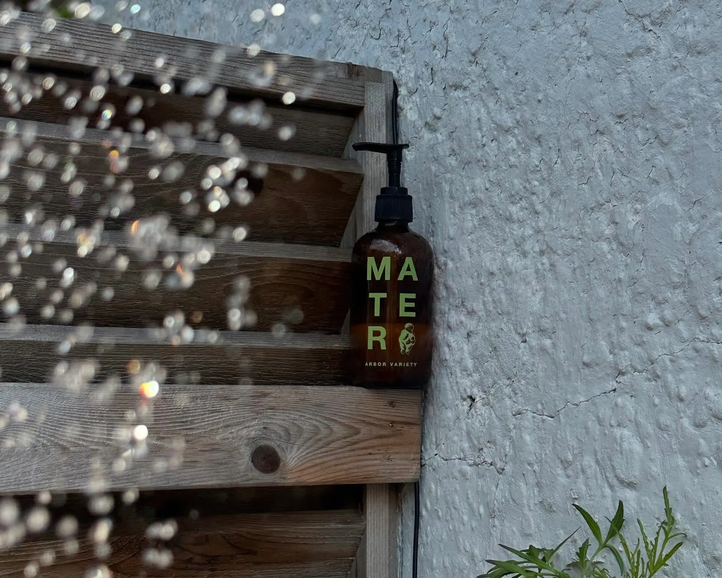 mater glass bottle soap on a wooden outdoor ledge