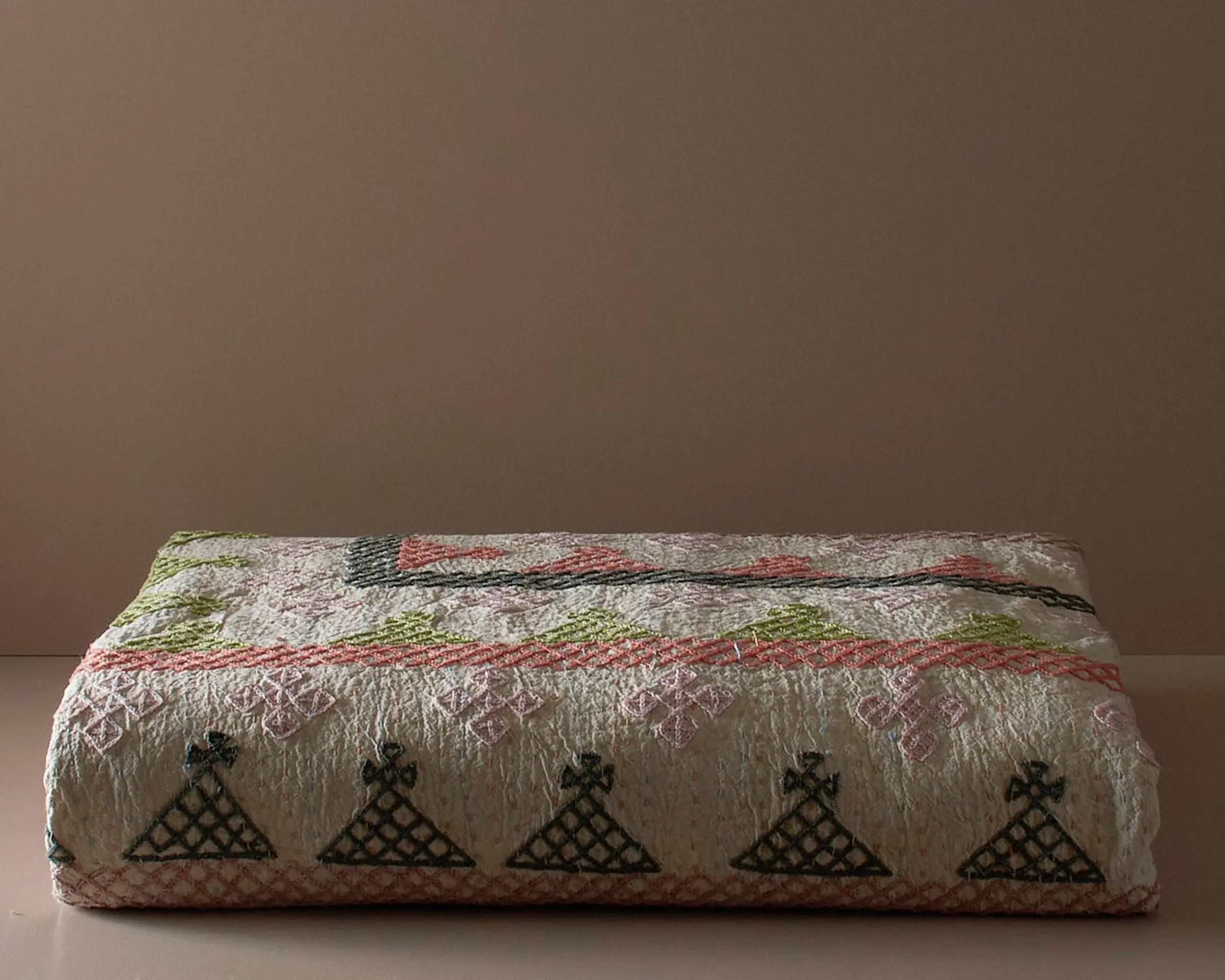 Stunning Queen size Cross-stitch Kantha bedcover from India on a neutral colored plinth