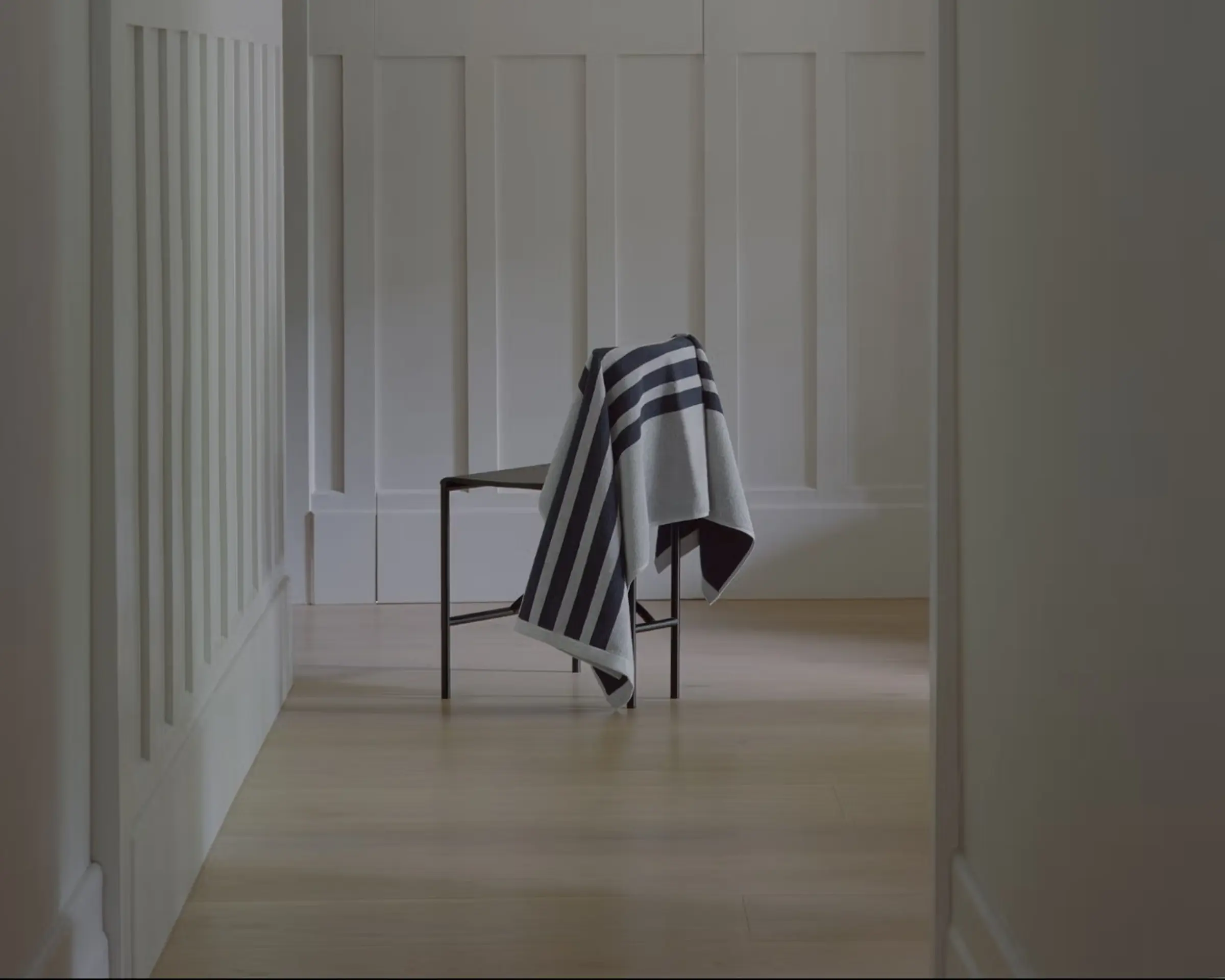A chair with a towel draped over it in the corner of a house