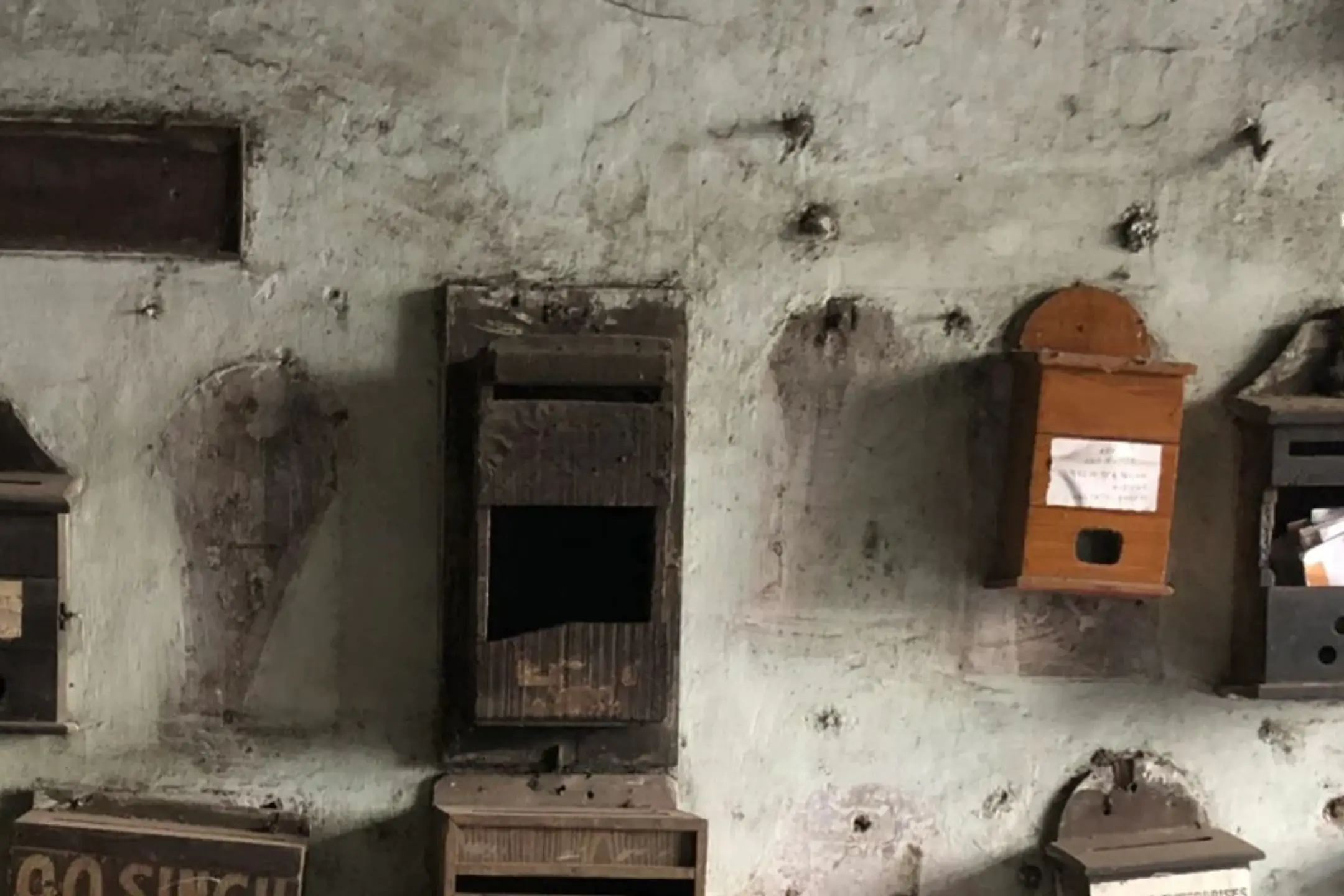 a collection of vintage wooden boxes on a concrete wall