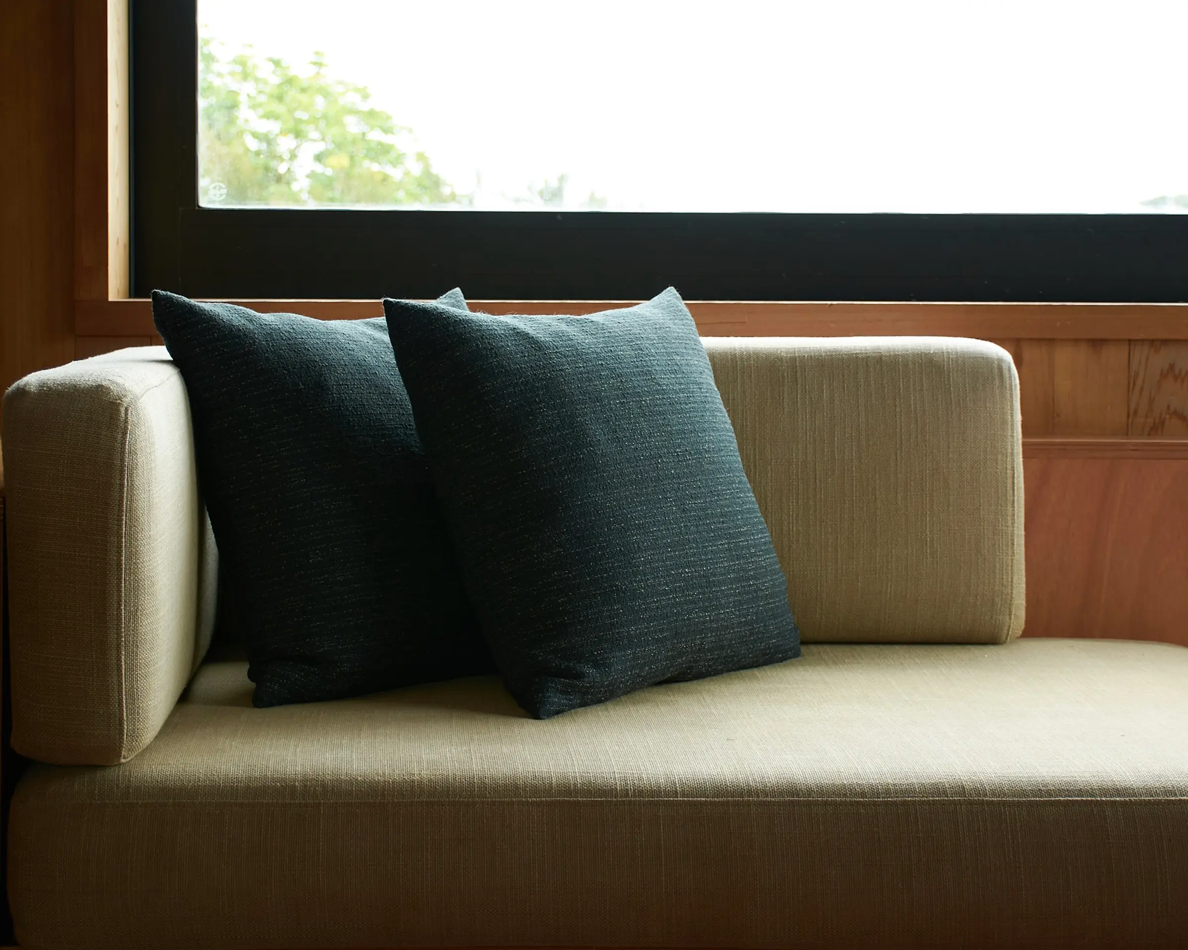 cushions on a couch under a window