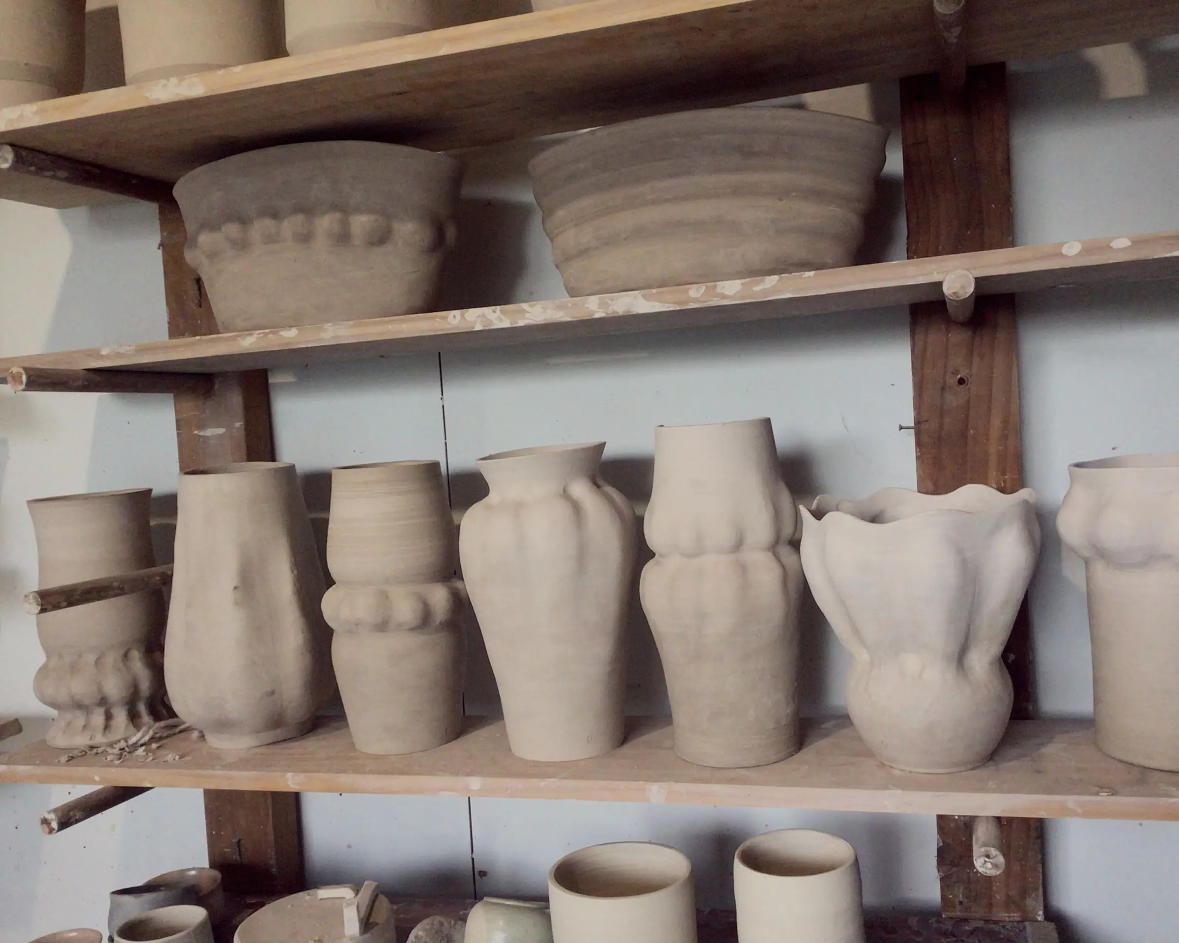 clay vases drying on a rack