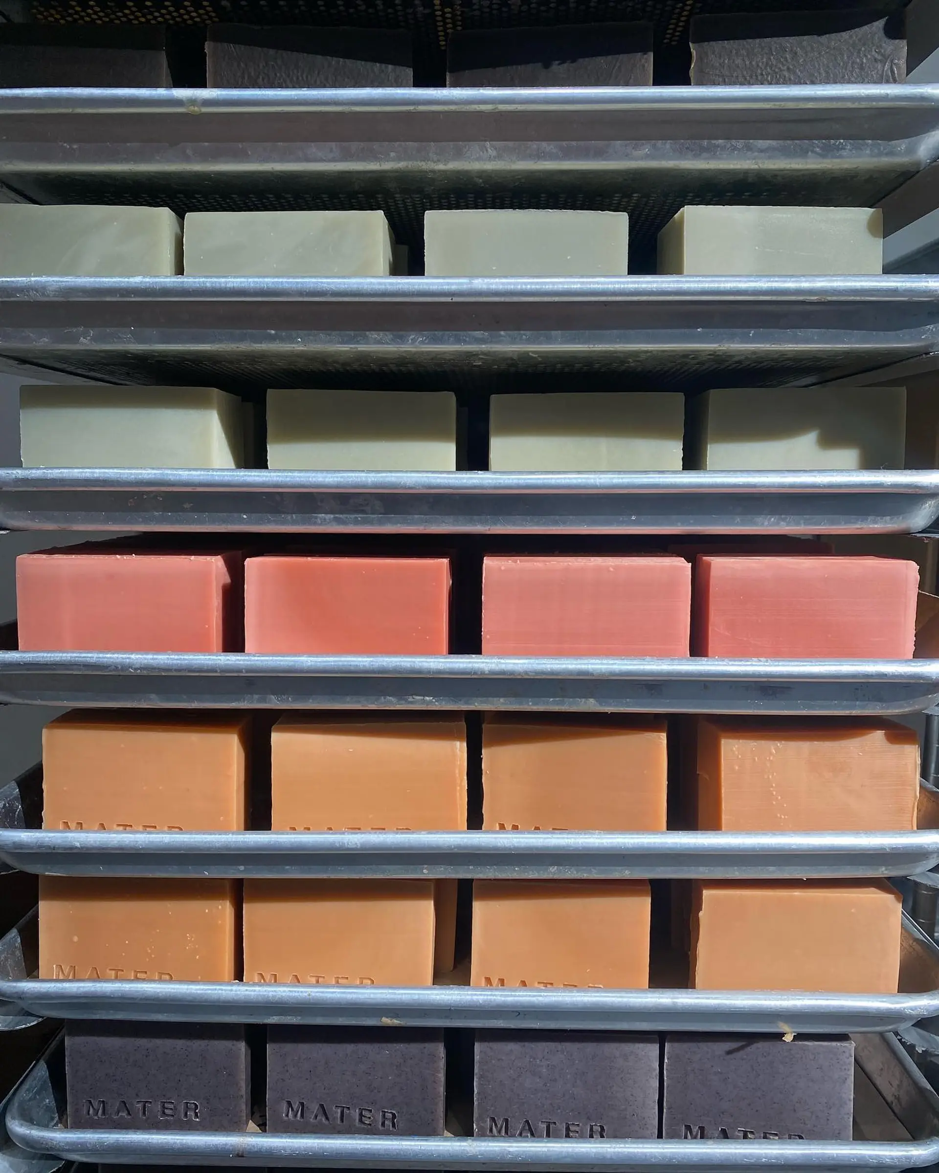 racks of mater soap drying out in the cold-process