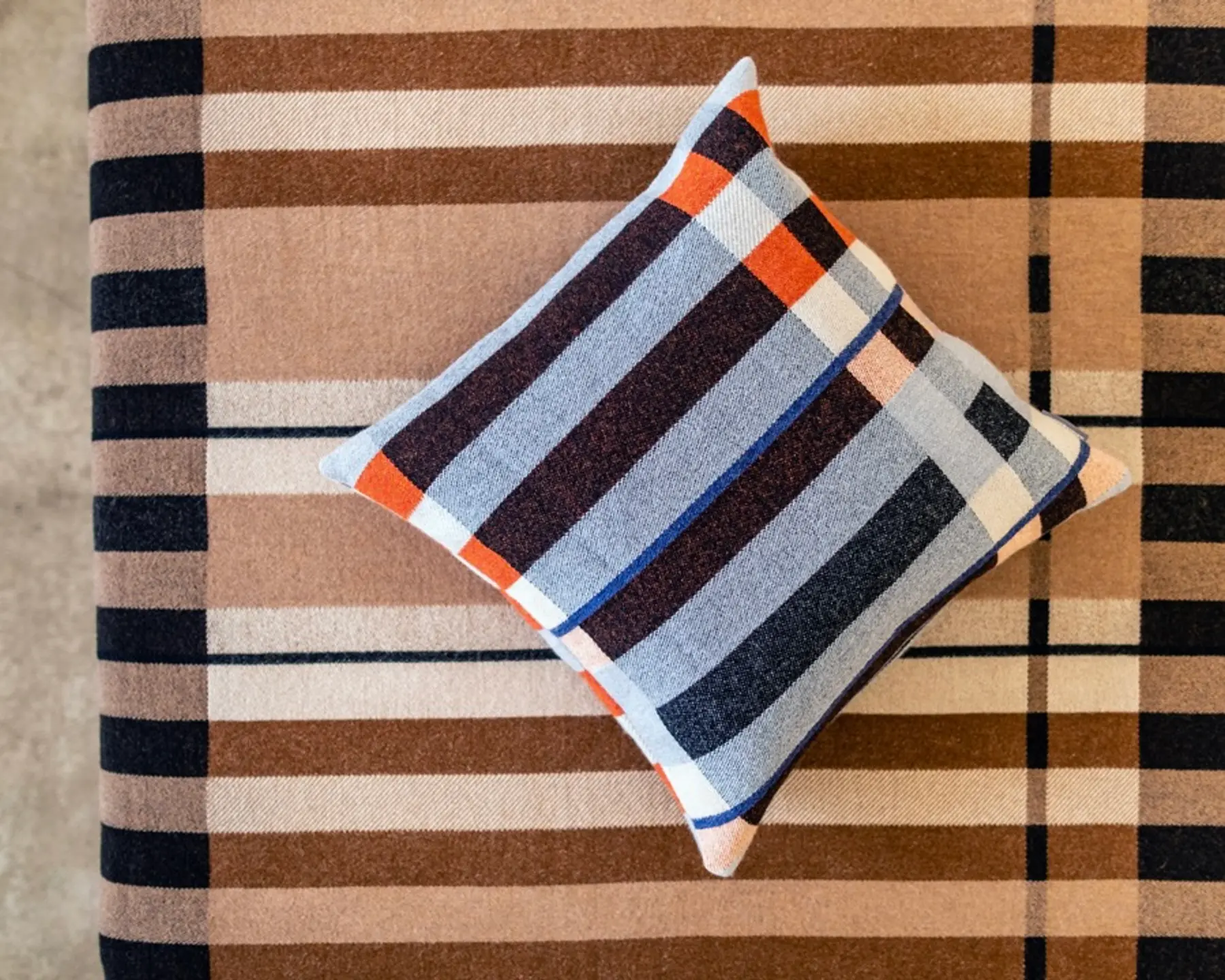 wool cushion and blanket on a bed
