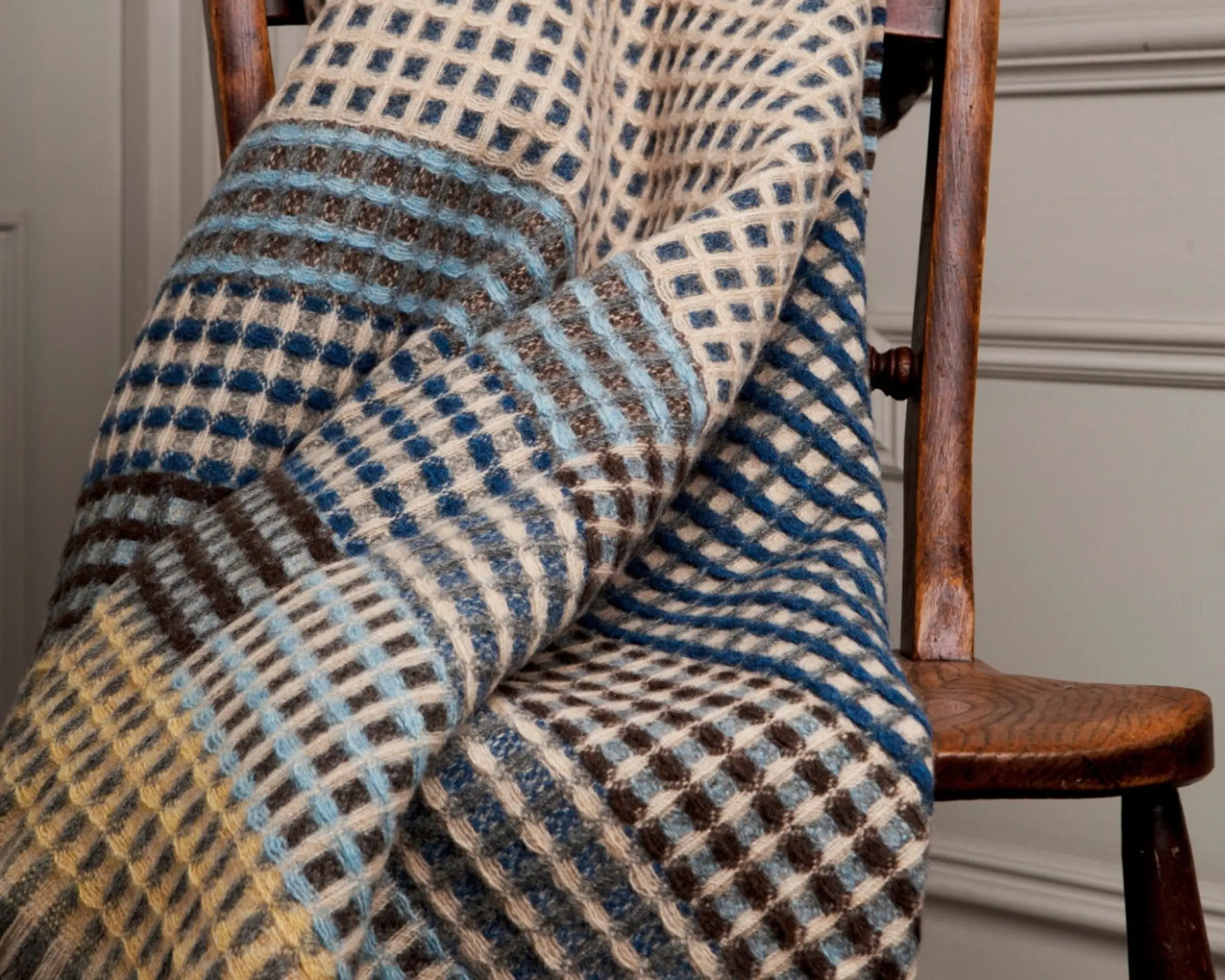 A wool blanket laid across a wooden vintage chair