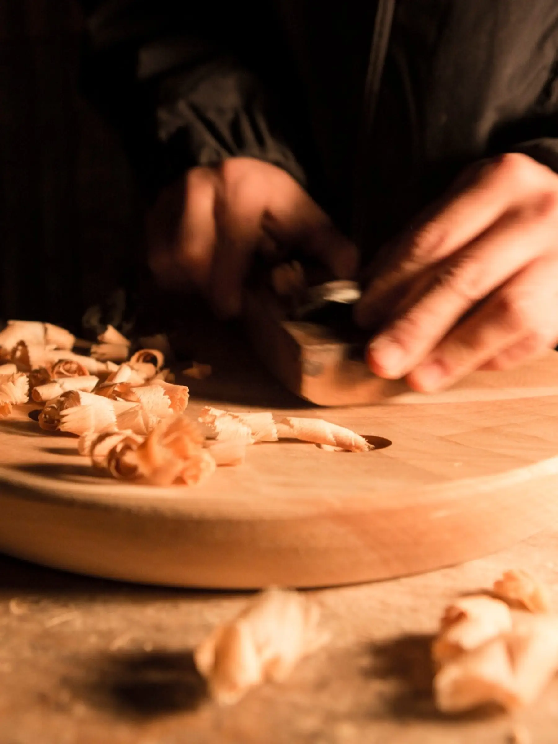 an image of Iba hand carving the base of a stool