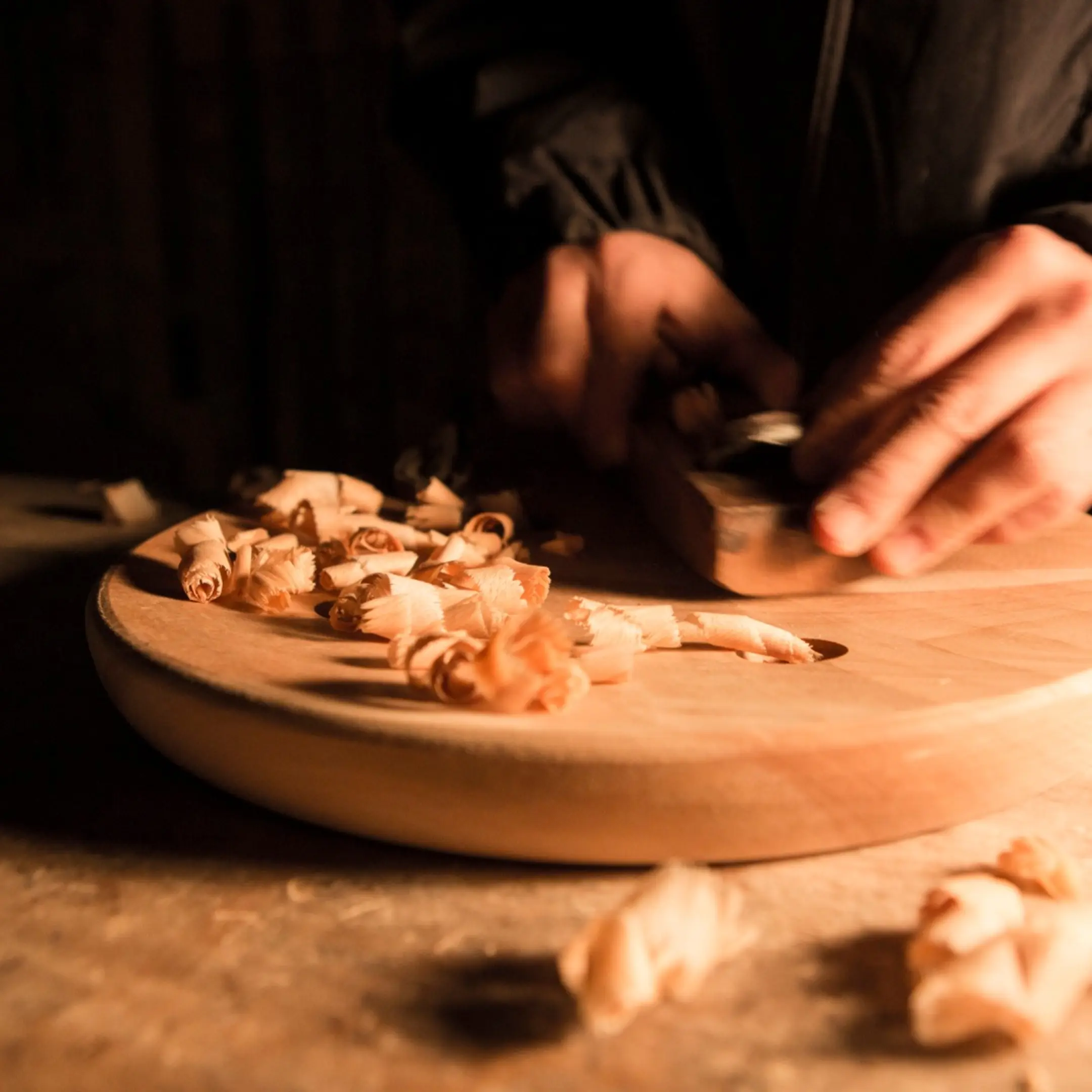 an image of Iba hand carving the base of a stool