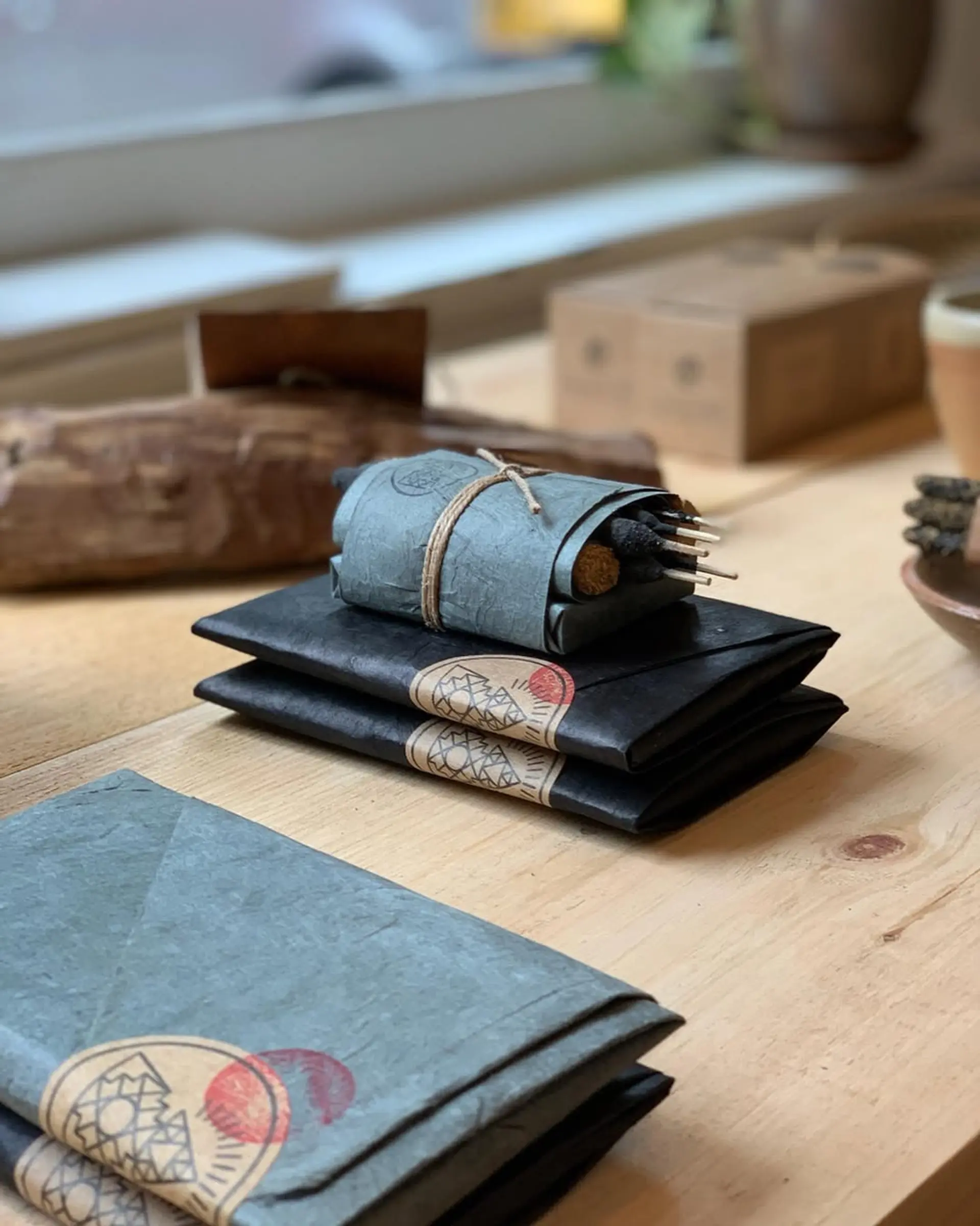 Incausa incense packages wrapped in handmade Lokta paper on a wooden table