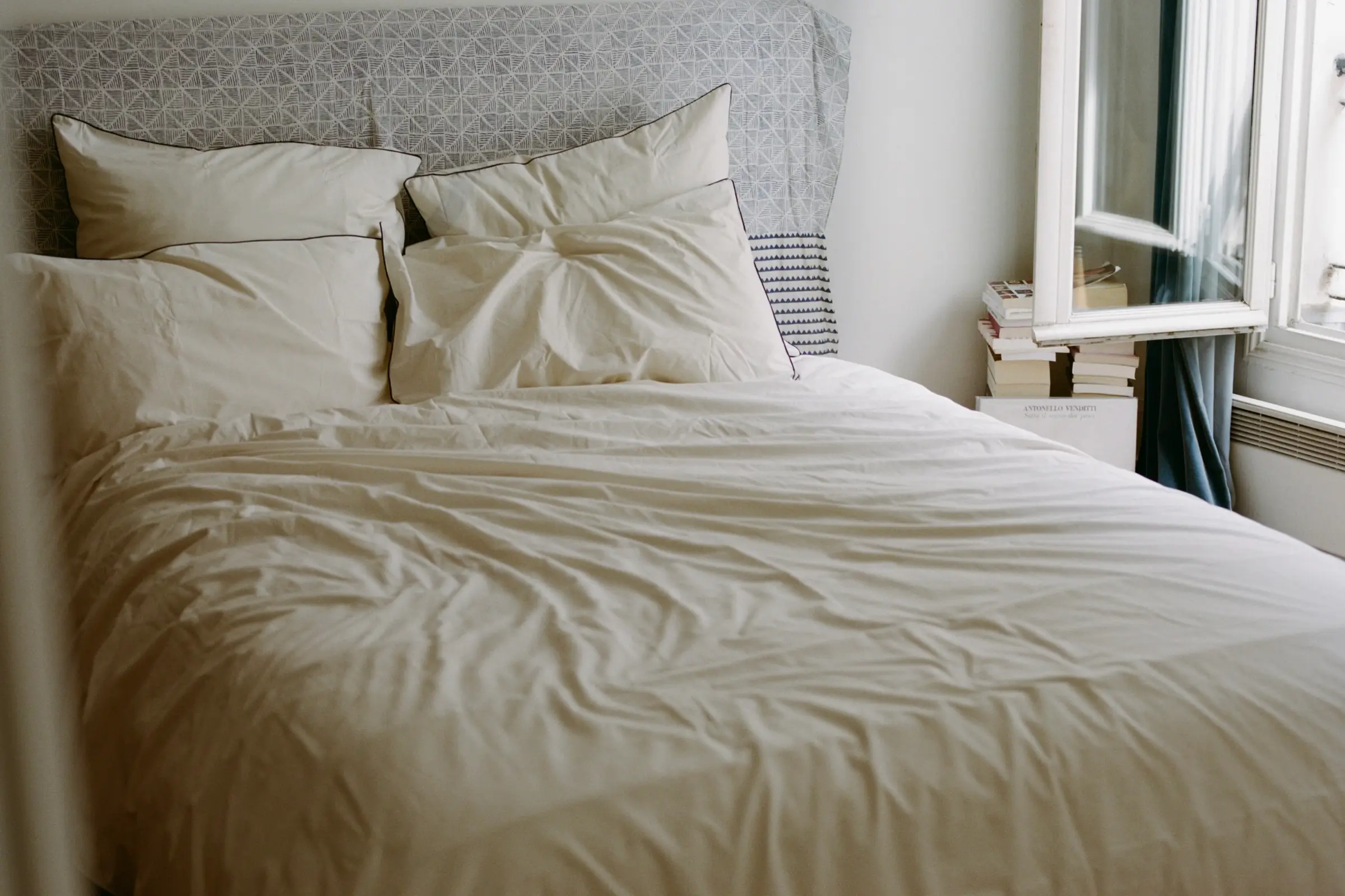 SUTRAM Canvas organic cotton percale bedding featuring a Canvas duvet cover, Canvas and Cinder piped pillowcases and Euro pillowcases, styled in a light-filled heritage bedroom.
