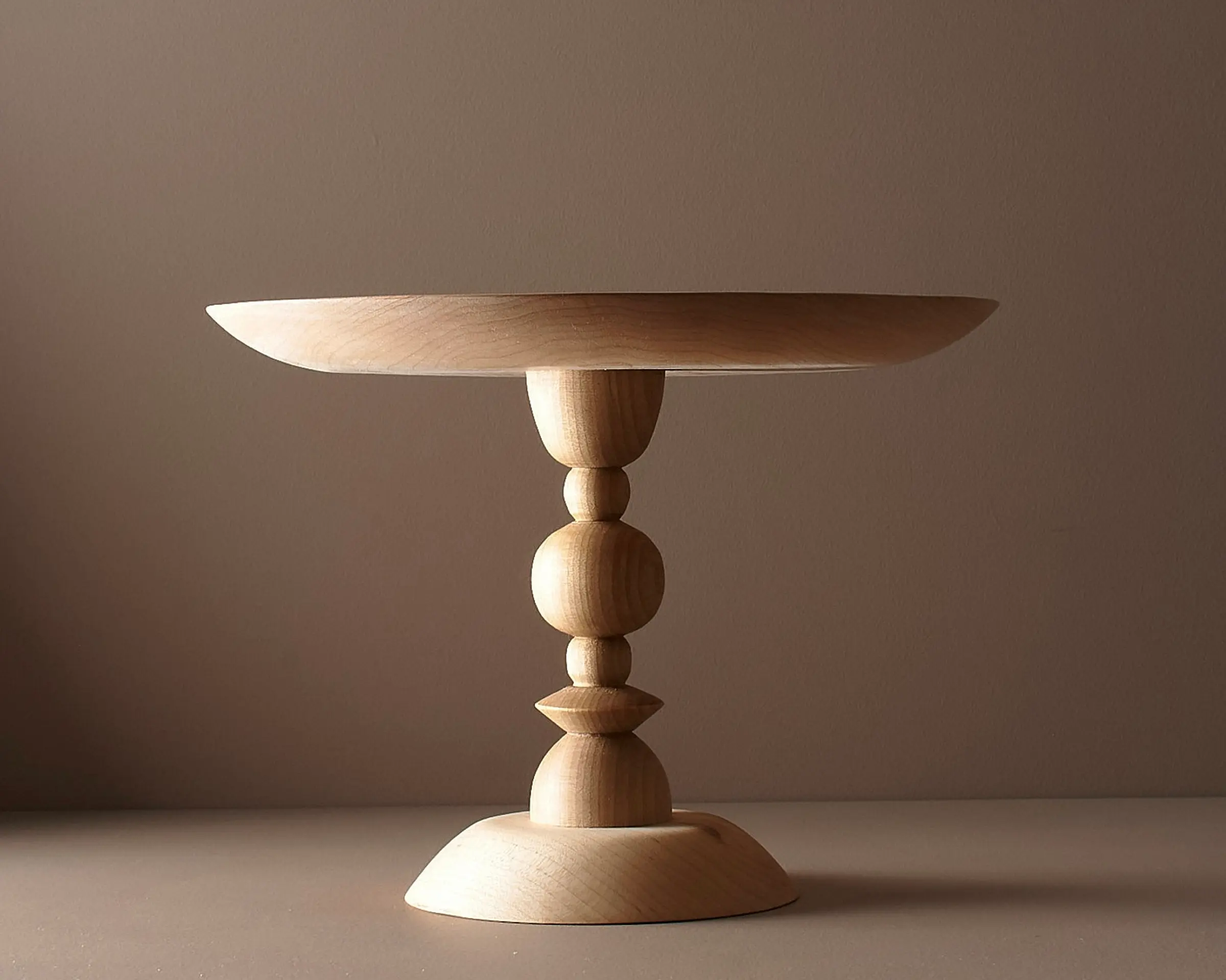 Elise mclauchlan maple tapered wooden cake stand on a brown moody background
