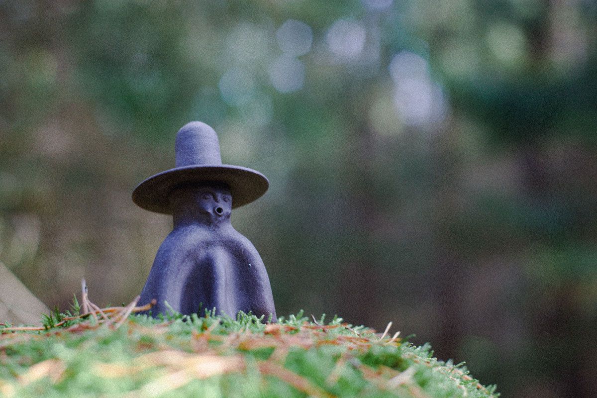 Ceres No 2 ceramic incense burner sitting on a grassy hill with a blurred forest in the background