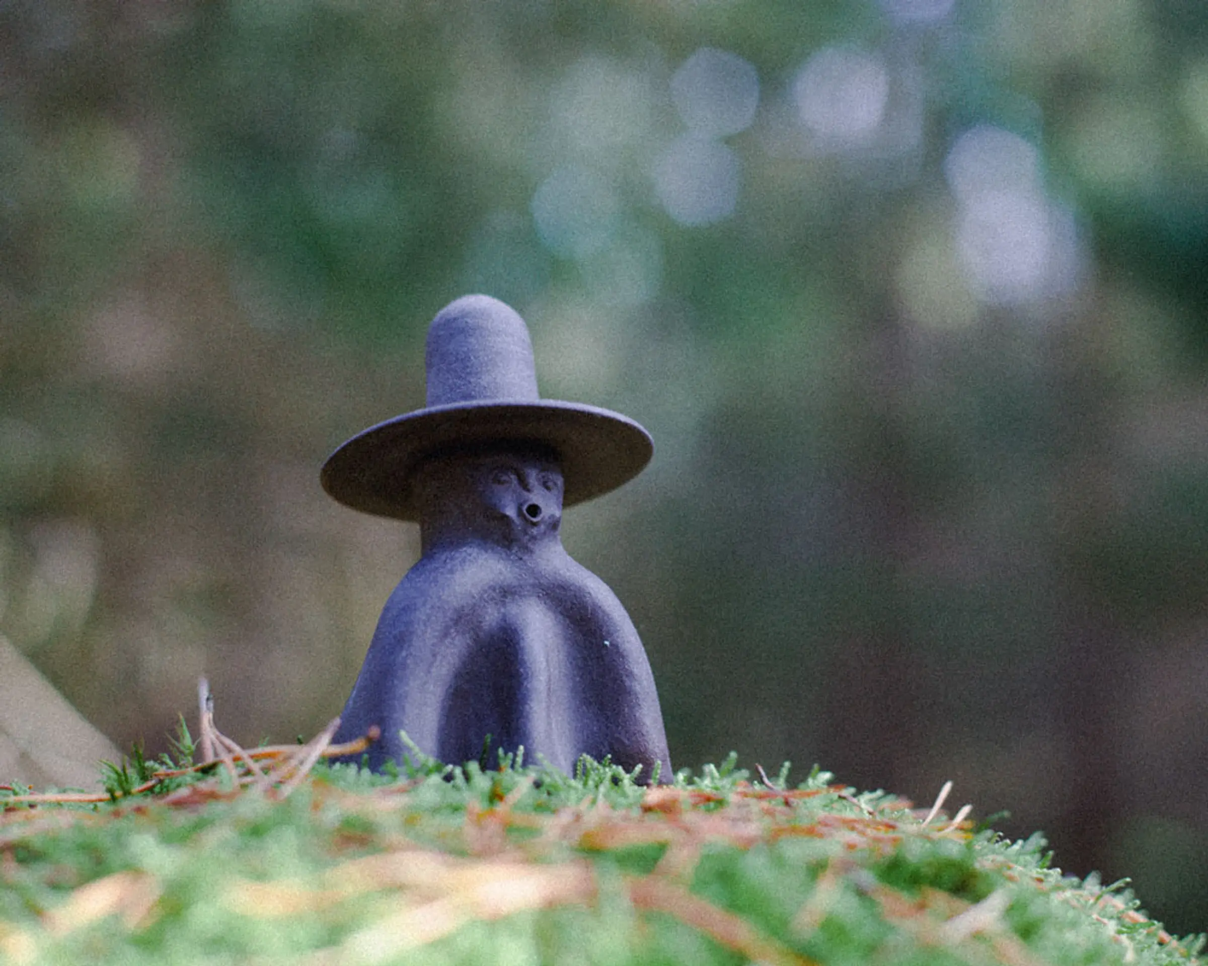 Ceres No 2 ceramic incense burner sitting on a grassy hill with a blurred forest in the background