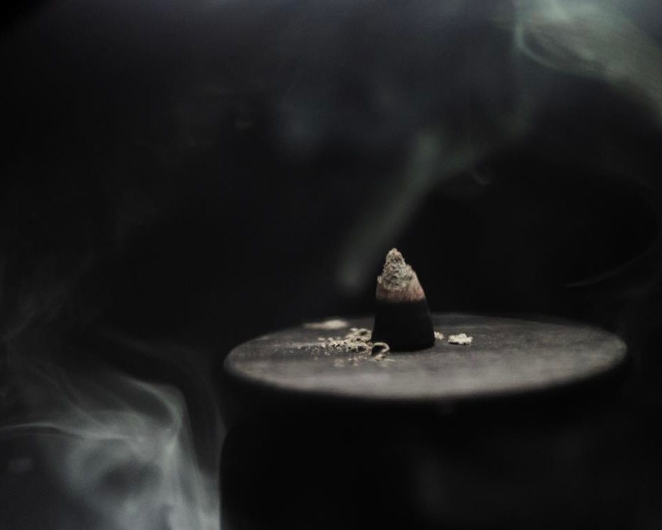 Incense cone lit ontop of a metal tin