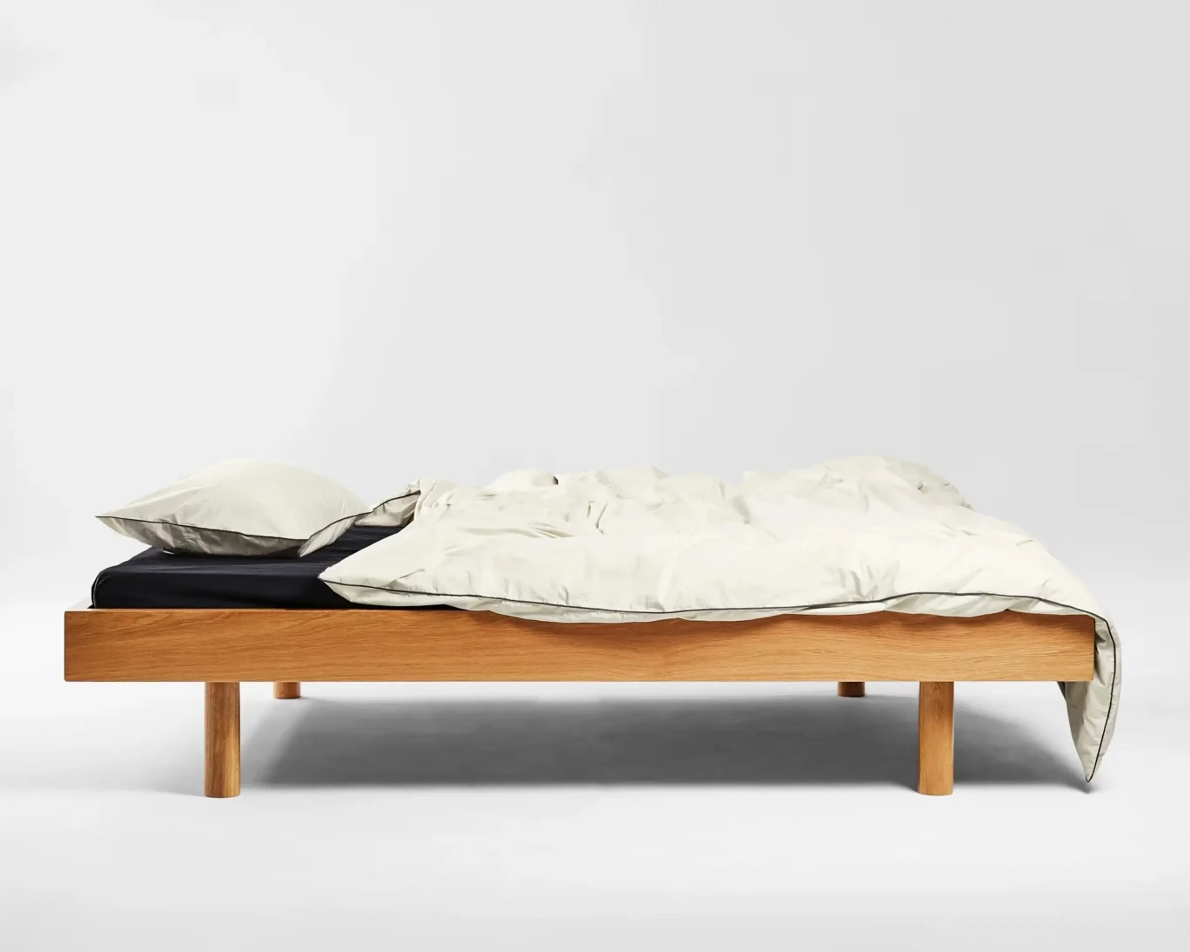 The Canvas Percale Pillowcase Set with Cinder Piping is woven in India from 300 thread count organic cotton percale. A wooden bed base set up with Sutrams percale bedding