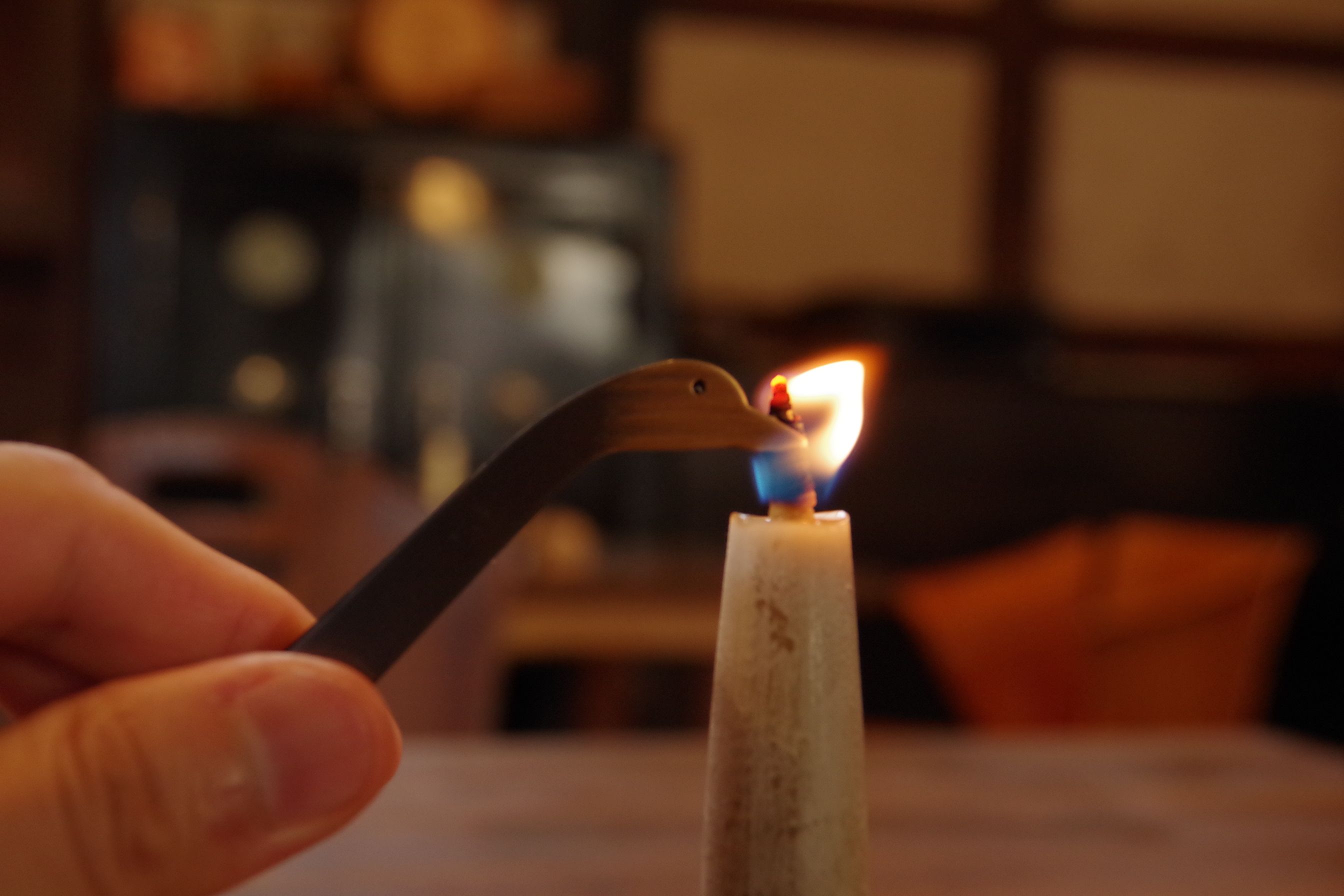 Metal duck shaped candle snuffer extinguishing a flame 