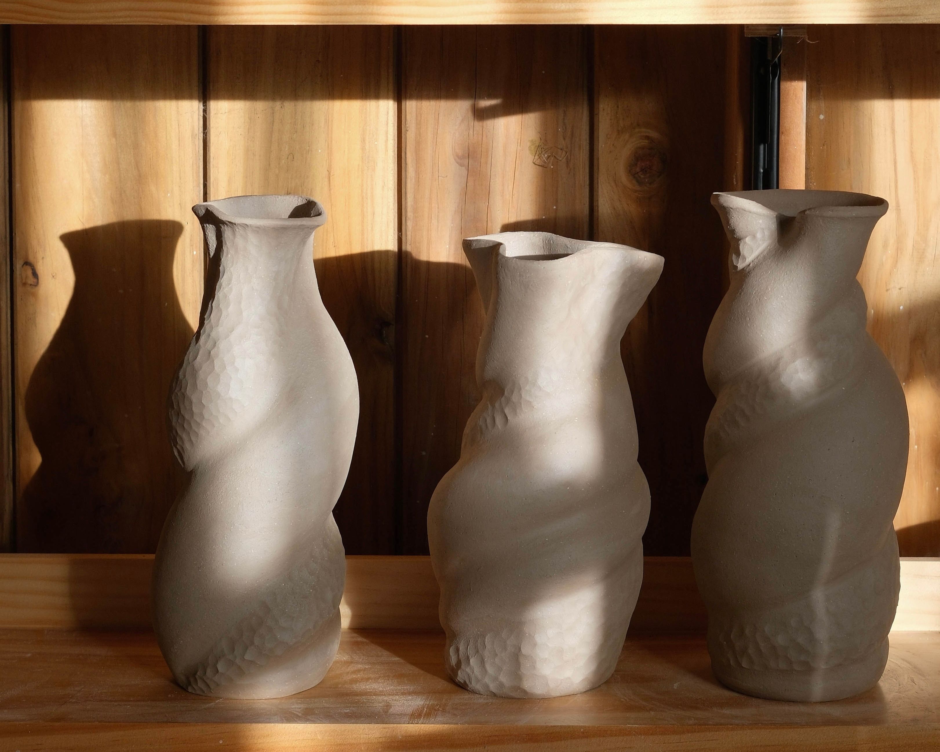 Three handmade sculptural stoneware vases by New Zealand ceramic artist Kaiqi Qiu, displayed in sunlight in her Grey Lynn studio.