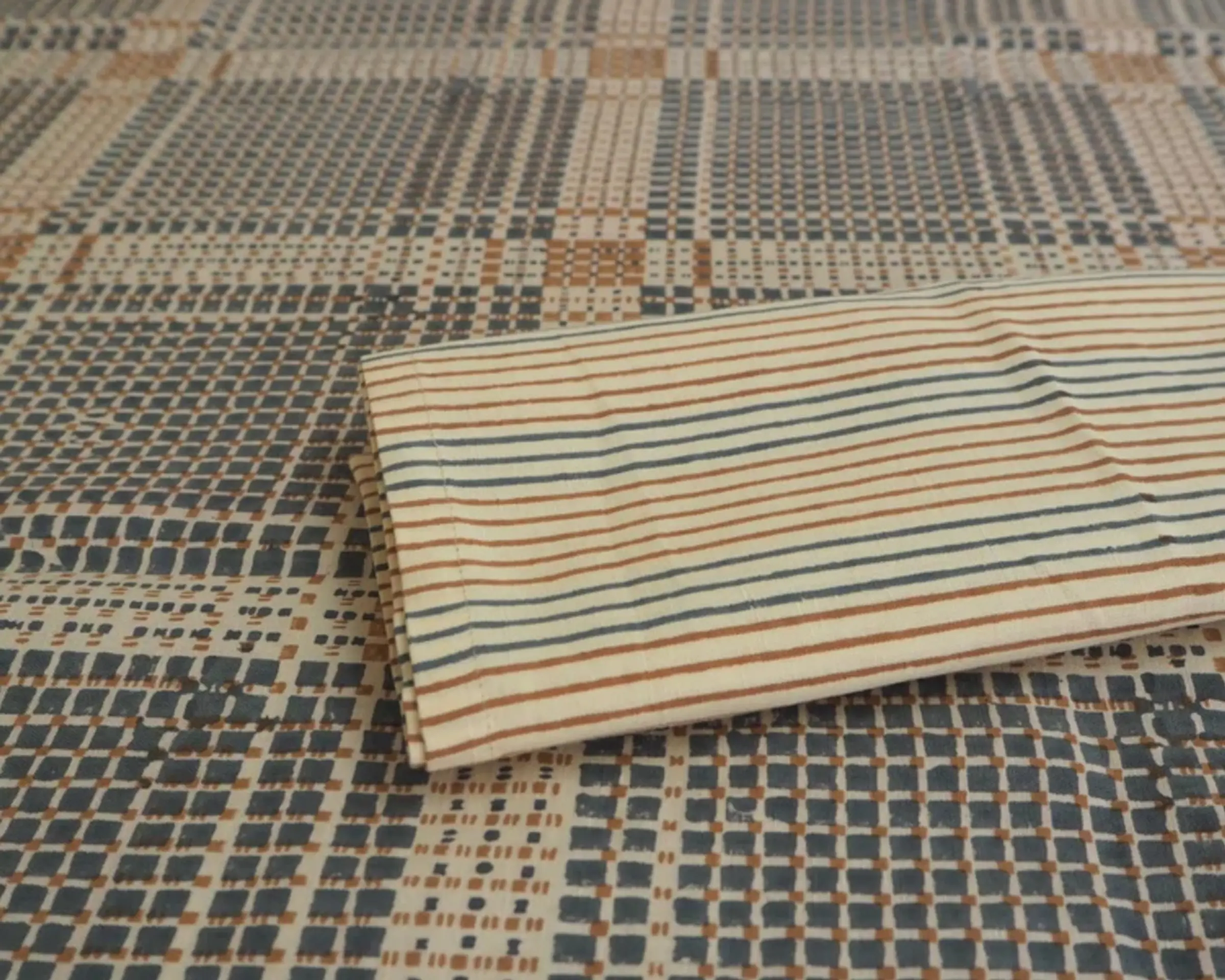 a close up detail of studio fords Acadia stripe napkins on the Acadia tablecloth