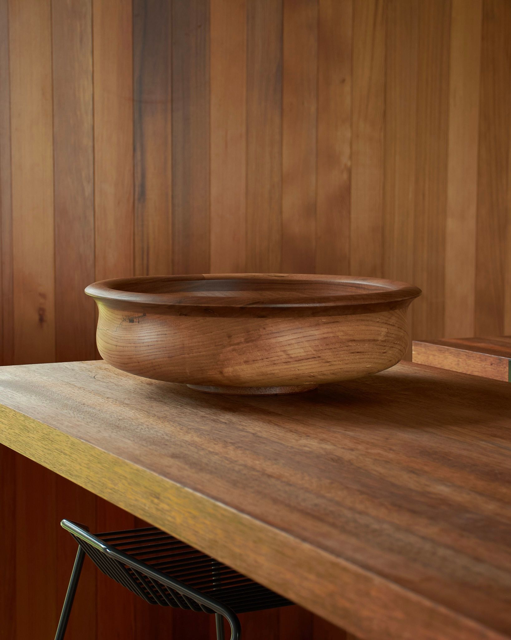 large wooden bowl on a wood kitchen bench with stool