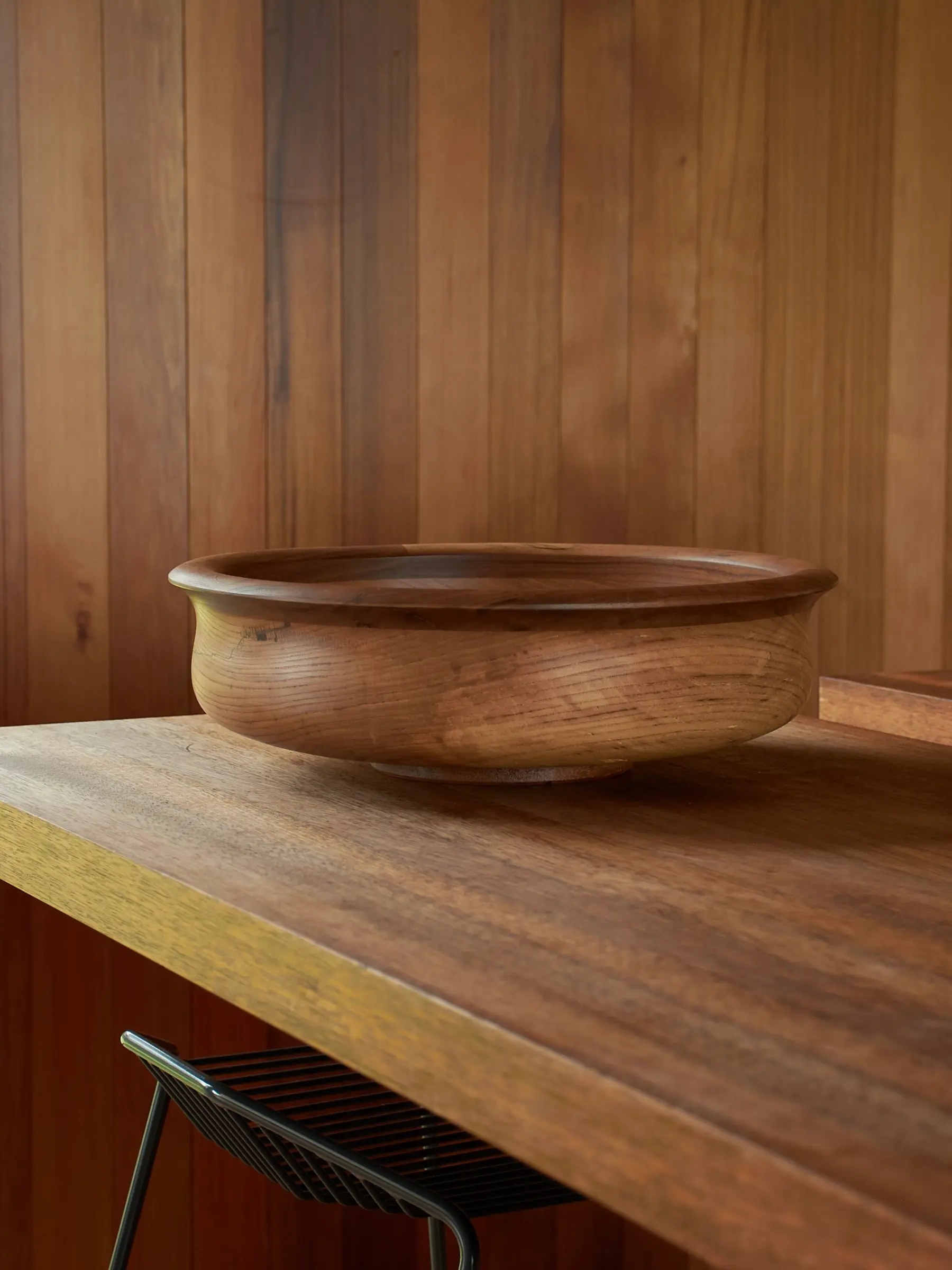 large wooden bowl on a wood kitchen bench with stool