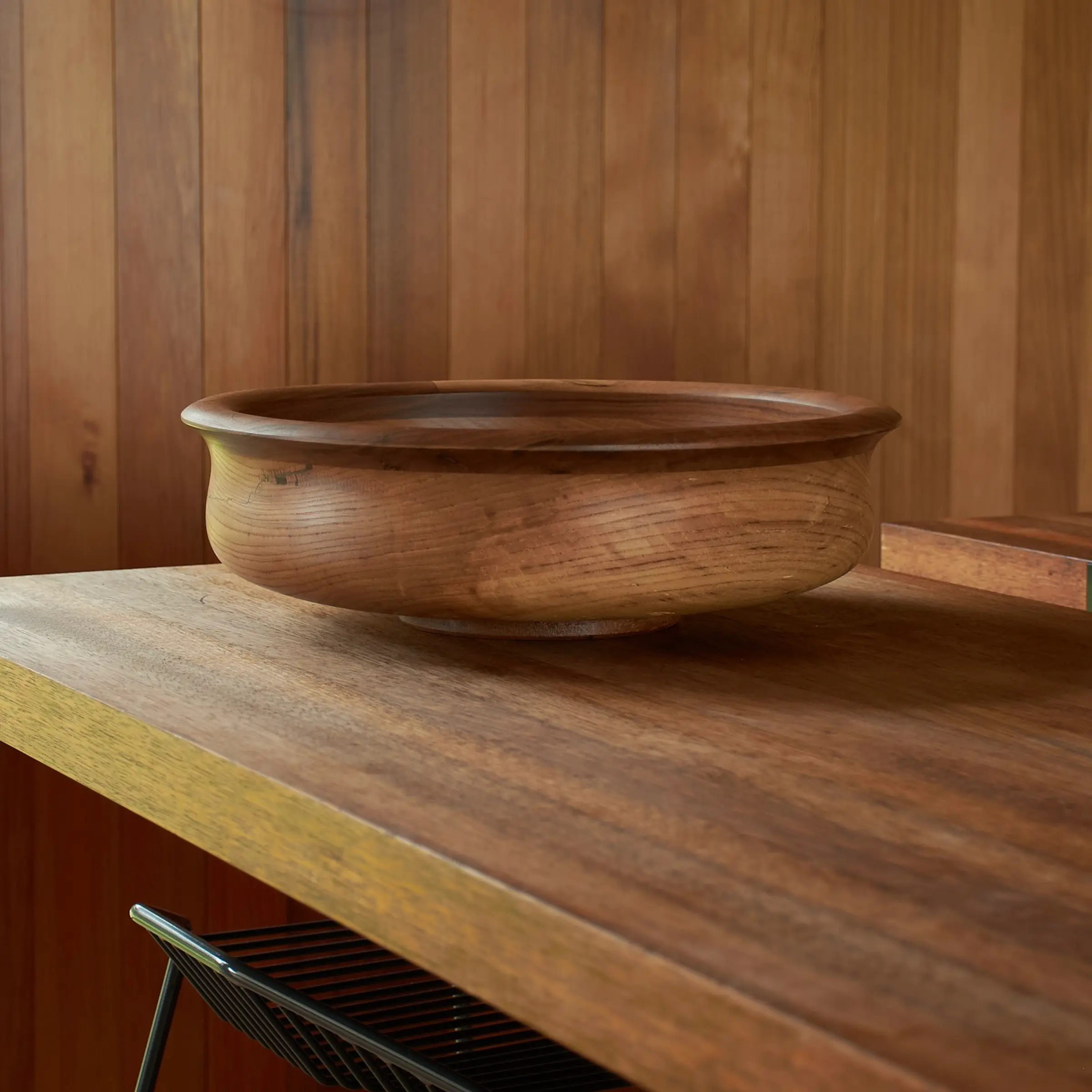 large wooden bowl on a wood kitchen bench with stool