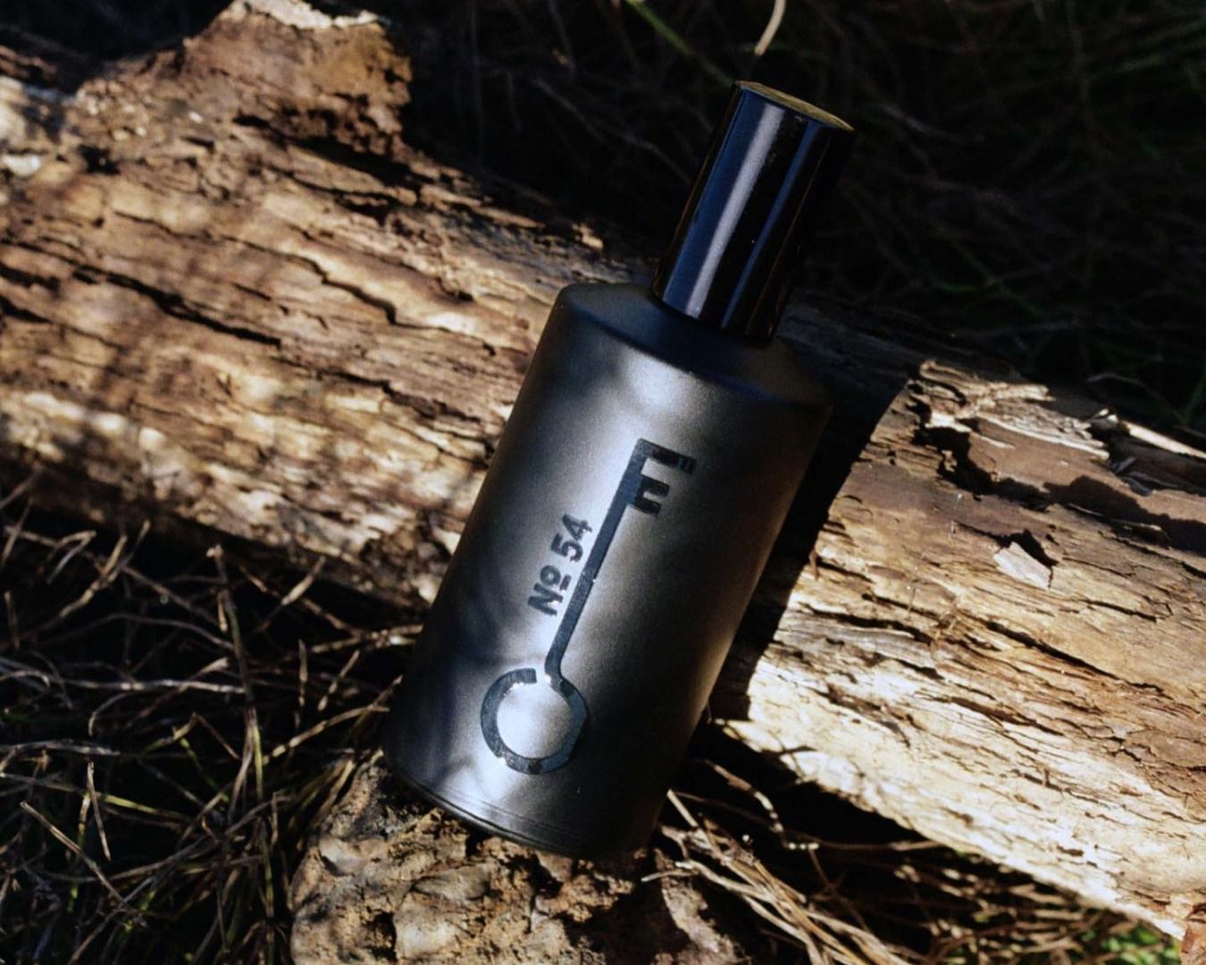 bottle of fischersund Fragrance on a log of wood and grass