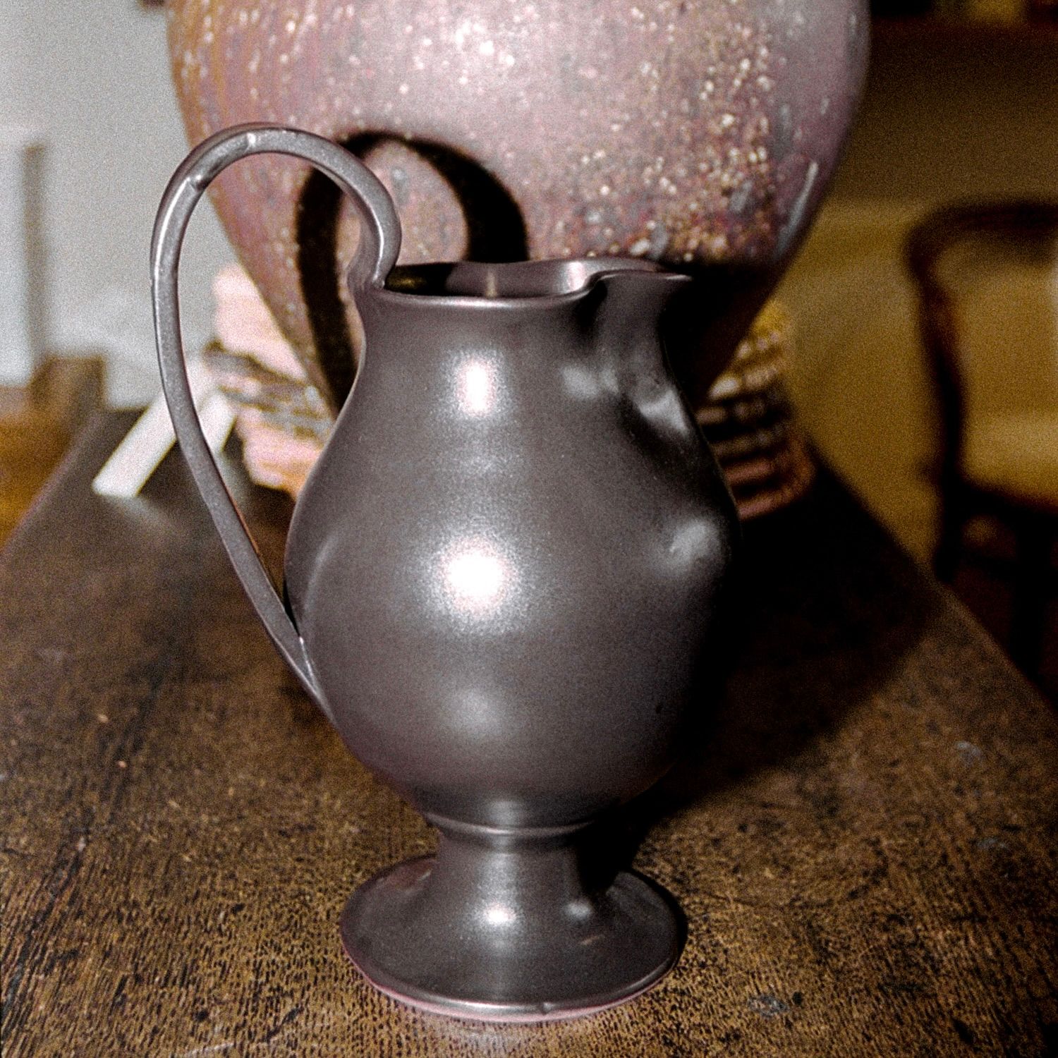 Blackware ceramic Jug in situ with a large vase on a wooden sideboard Aileen Chen.