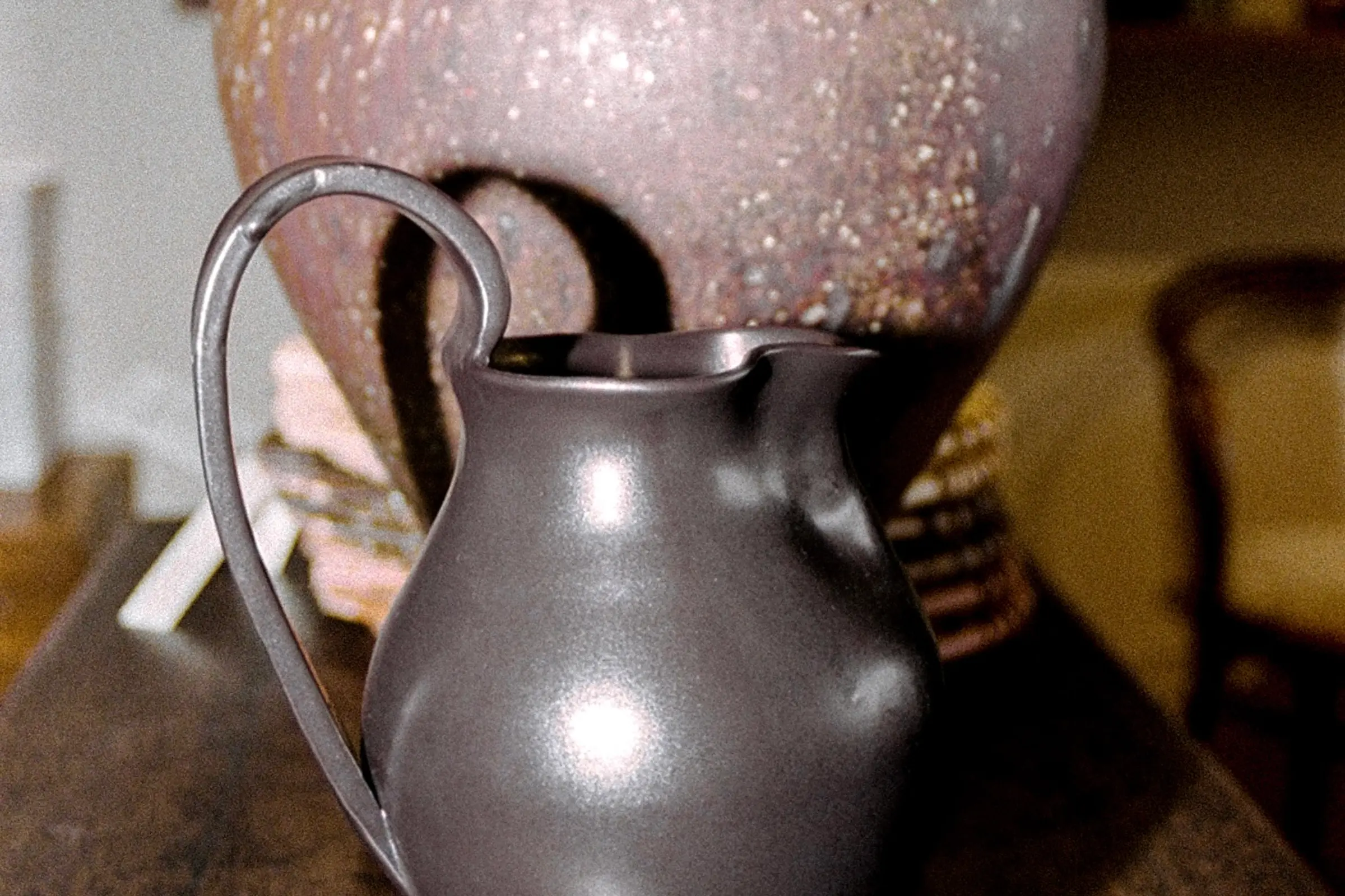 Blackware ceramic Jug in situ with a large vase on a wooden sideboard Aileen Chen.