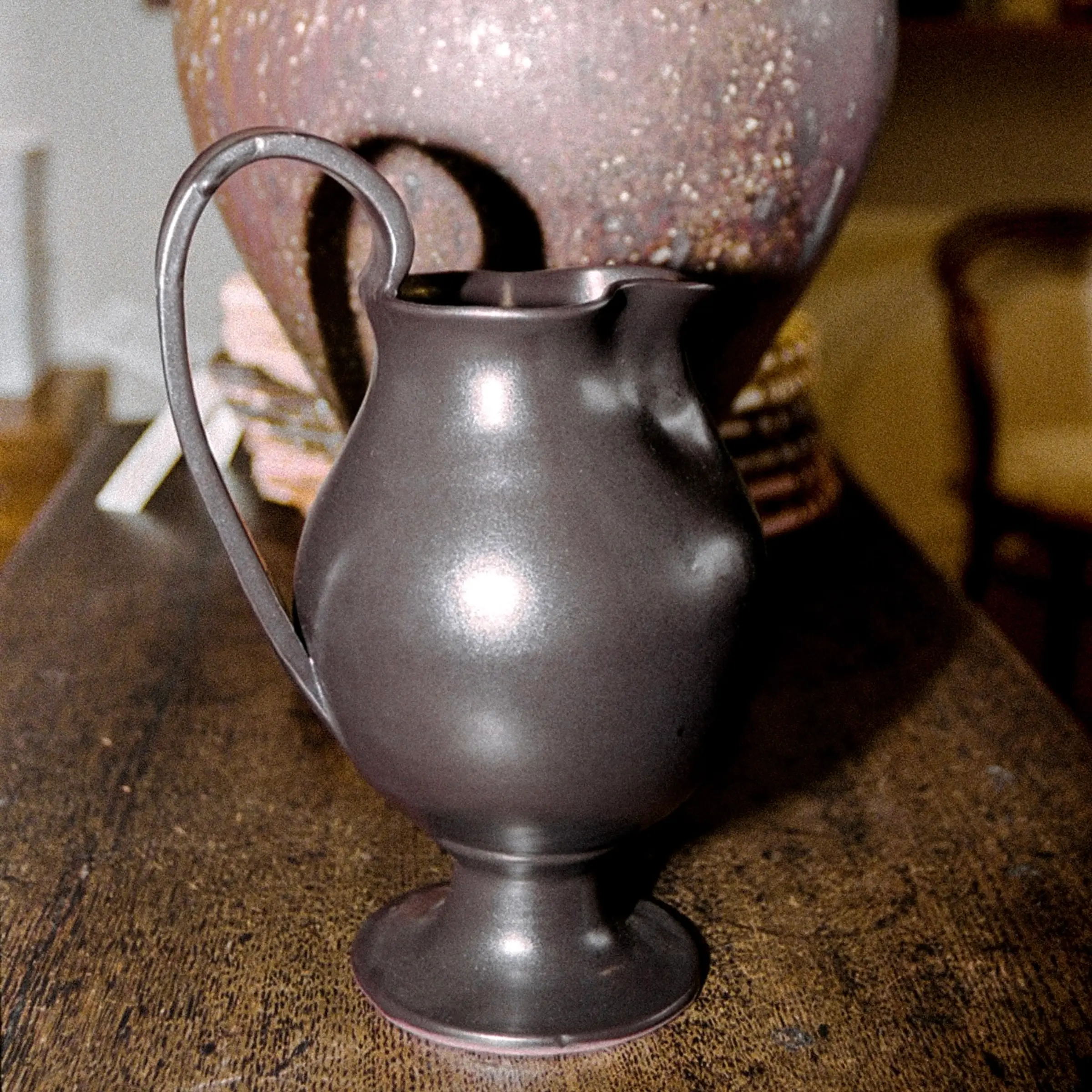 Blackware ceramic Jug in situ with a large vase on a wooden sideboard Aileen Chen.