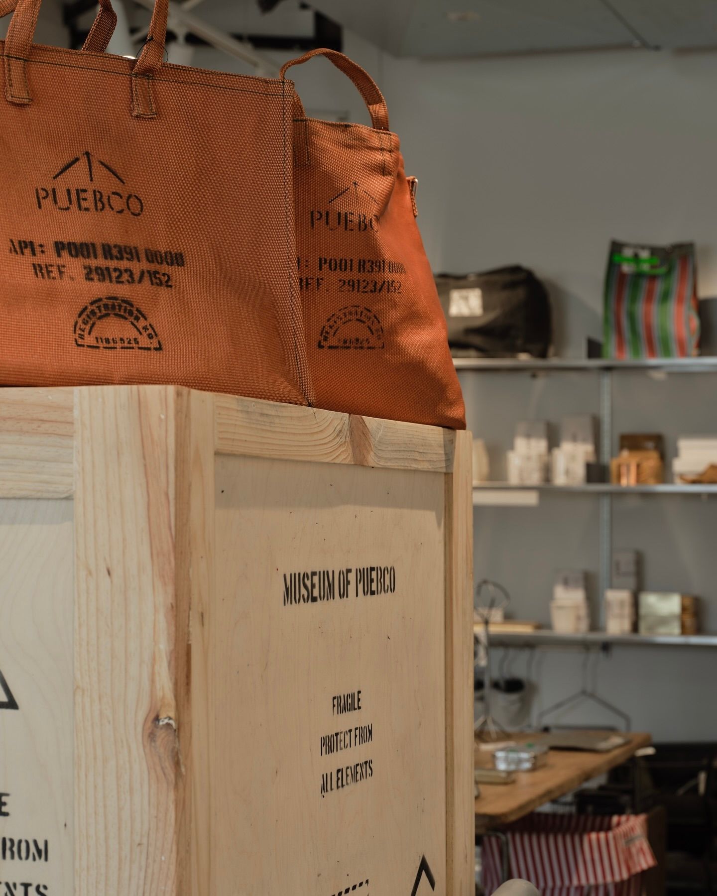 Puebco tote bag onto of a wooden crate in a shop