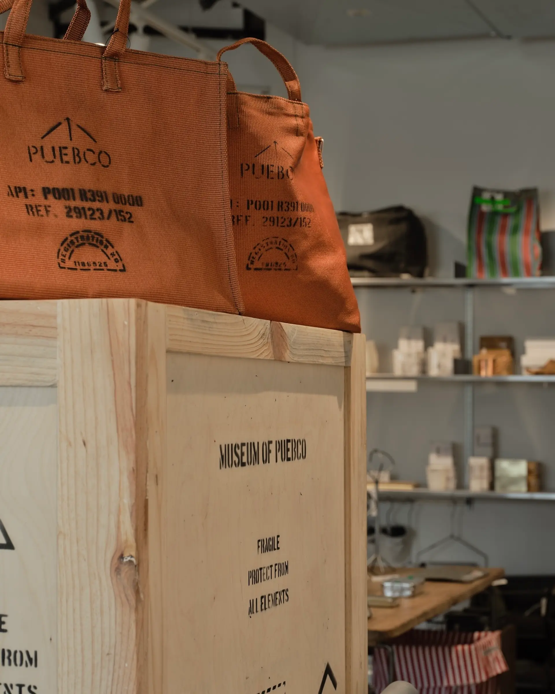 Puebco tote bag onto of a wooden crate in a shop