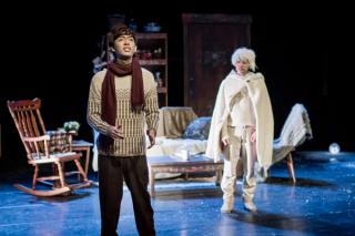 Leon Hong singings in a sweater and red scarf, in a fairytale-vibe stage