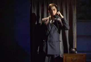 Leon Hong plays an serious character in a navy blue smart suit.