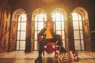 Leon Hong sitting in a royal chair with a skateboard under his foot