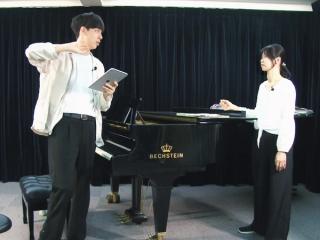 Leon Hong coaches a singer in front of a piano in ABRSM Taiwan.