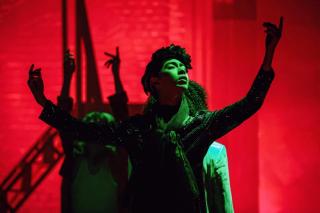 Leon Hong dances on a stage filled with red & green lights