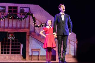 Leon Hong singing and dancing with little Annie in a smart suit