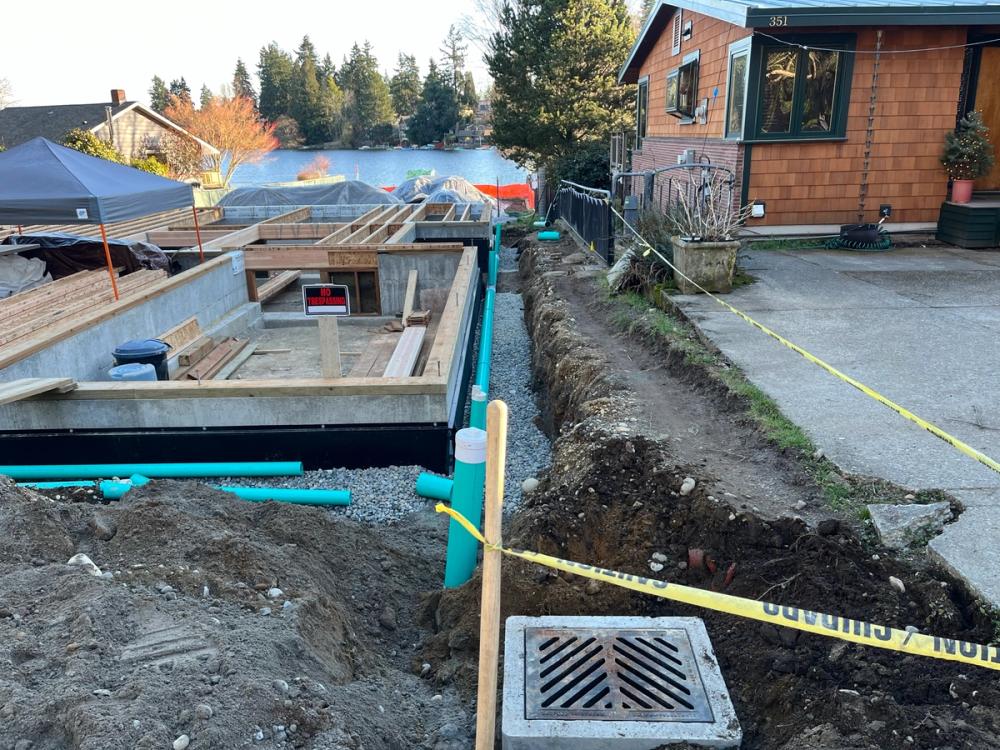 Catch basin and rigid PVC drain line with cleanouts along a new foundation near Bitter Lake in Seattle