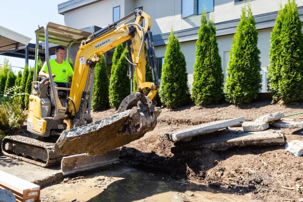 Excavator clearing and grading a residential site