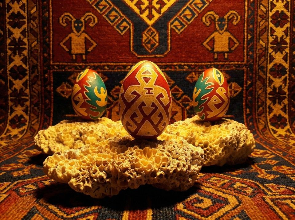 Kilim önünde turuncu ve mavi geometrik motifli yumurtalar