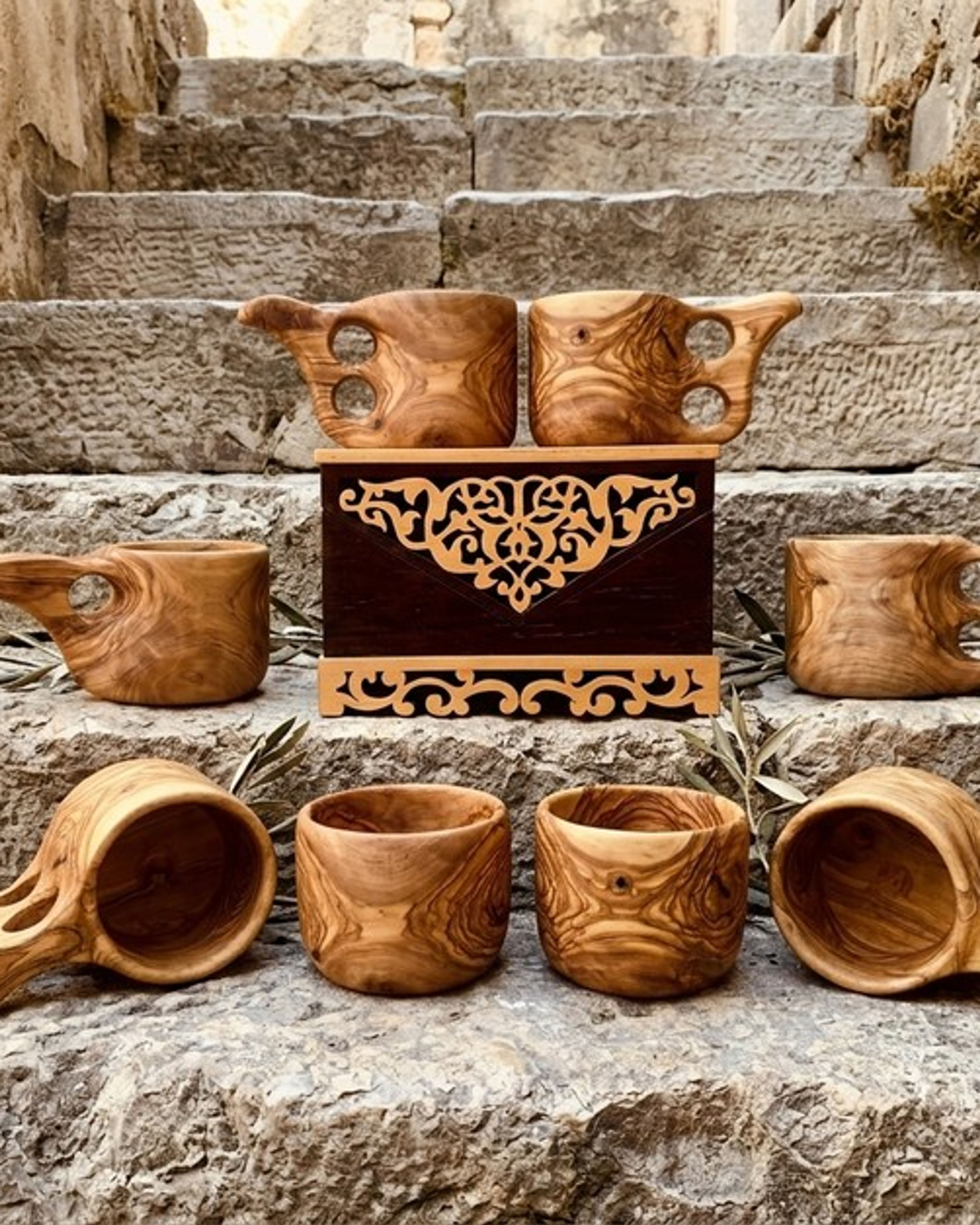 Taş basamaklar üzerinde zeytin ağacından oyma bardaklar ve tütsülük