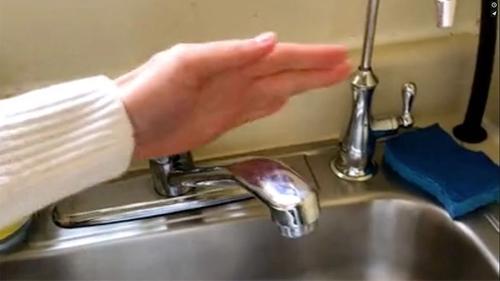 a hand over a sink, beginning to wash