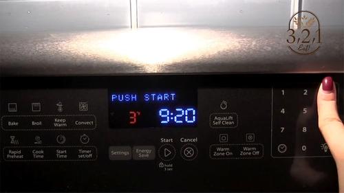 a finger on the number pad of a microwave oven, etting the time at 3